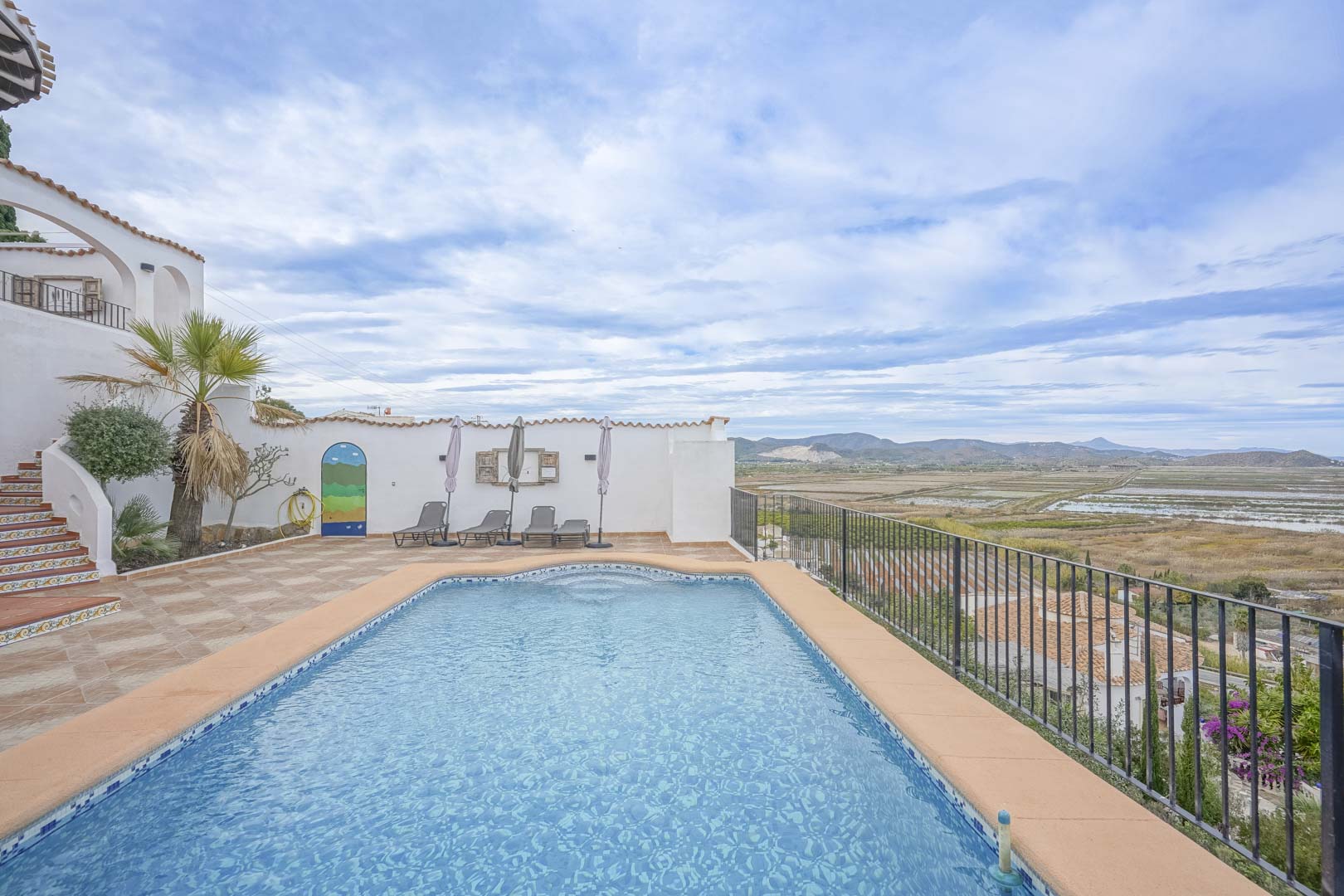 Vista de la piscina privada con baldosas azules y terraza con vistas panorámicas a la reserva natural.