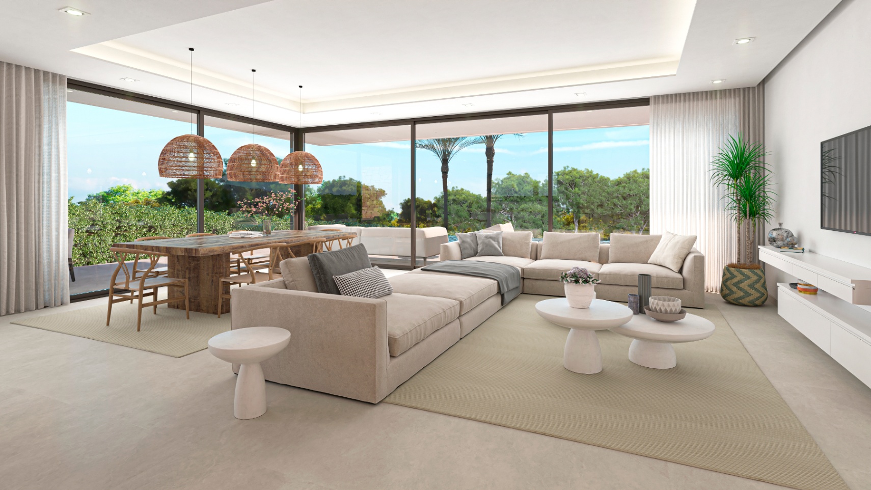 Amplio salón-comedor con mesa de madera rústica y sofás modulares beige, iluminado por lámparas colgantes de mimbre.