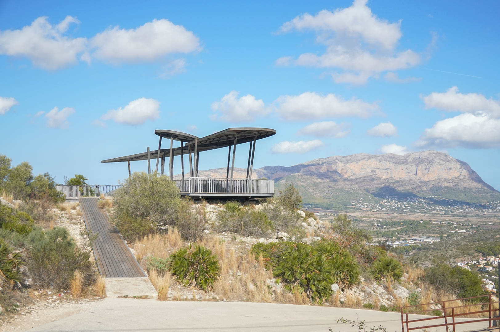 Mirador de diseño contemporáneo con estructura metálica y pasarela de madera, que ofrece vistas panorámicas al valle y al macizo del Montgó.