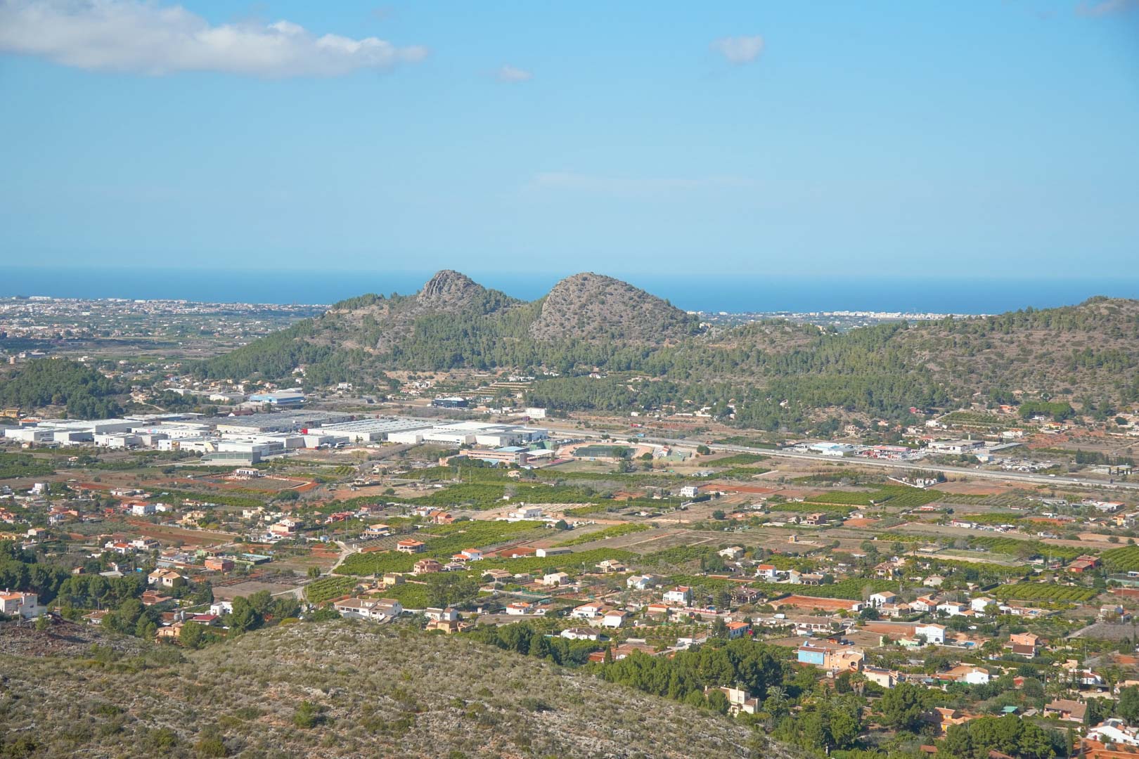 Vistas panorámicas desde la propiedad hacia el valle de Pedreguer, destacando las montañas circundantes y el mar Mediterráneo en el horizonte bajo un cielo despejado.