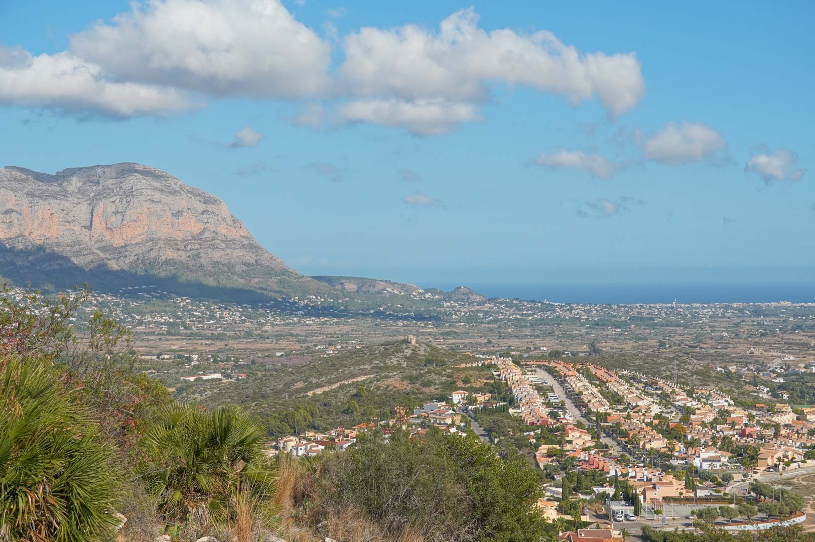 Vistas panorámicas desde la propiedad que abarcan el valle de Pedreguer, la majestuosa montaña y el horizonte del mar Mediterráneo bajo un cielo despejado.