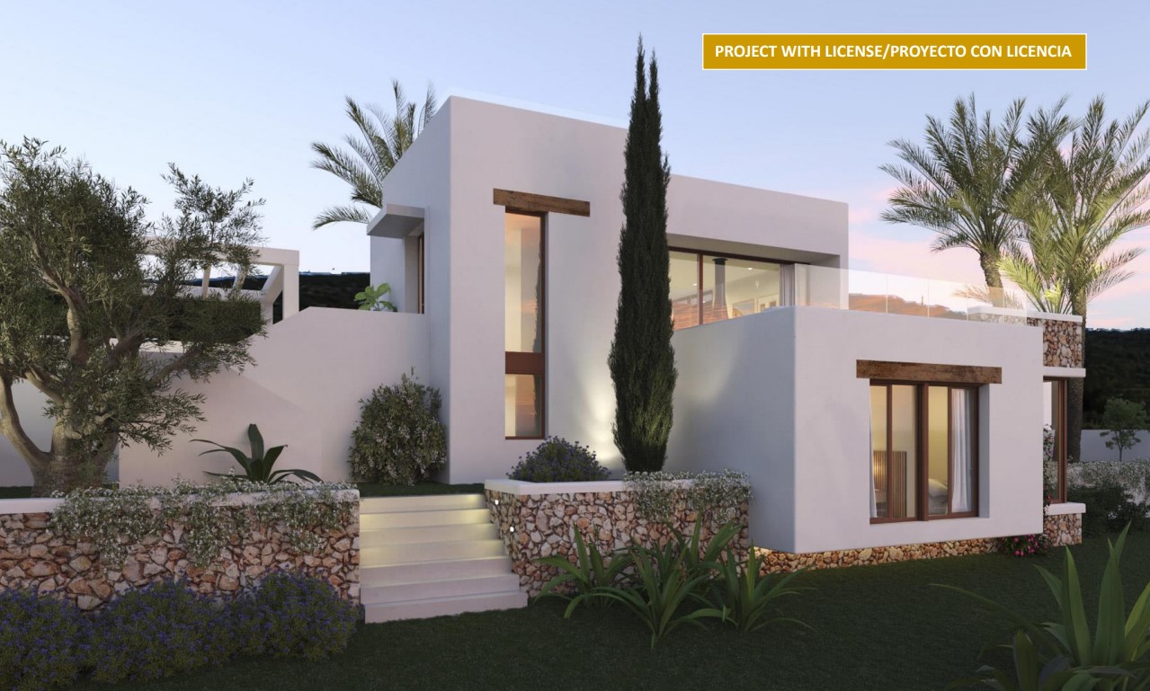 Fachada exterior de estilo ibicenco con muros de piedra natural, vigas de madera y escaleras iluminadas que integran la arquitectura con el jardín mediterráneo.