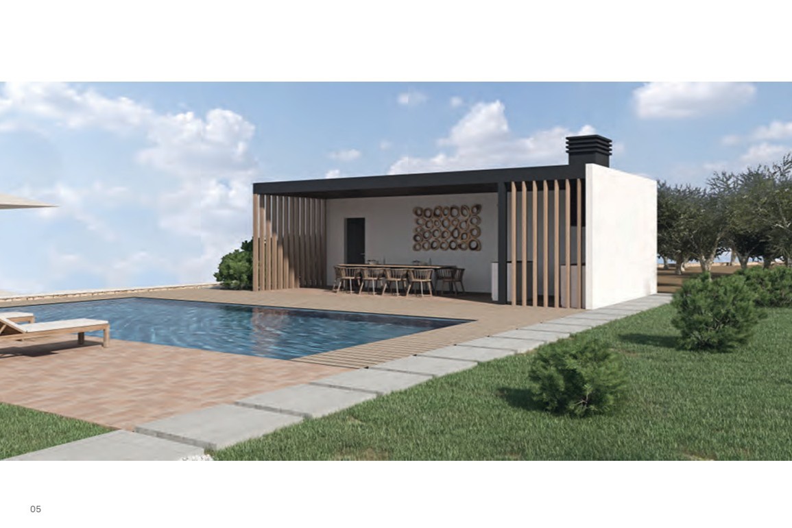 Comedor exterior cubierto con lamas de madera verticales, cocina integrada y amplia mesa, ubicado junto a la piscina y rodeado de zonas verdes.