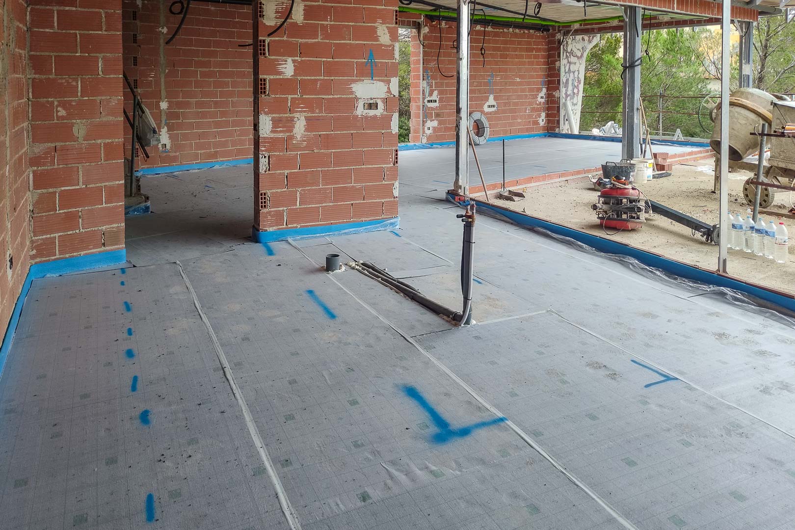 Avance de obra: preparación de forjados con membrana aislante y preinstalación de tuberías para el sistema de climatización y fontanería.