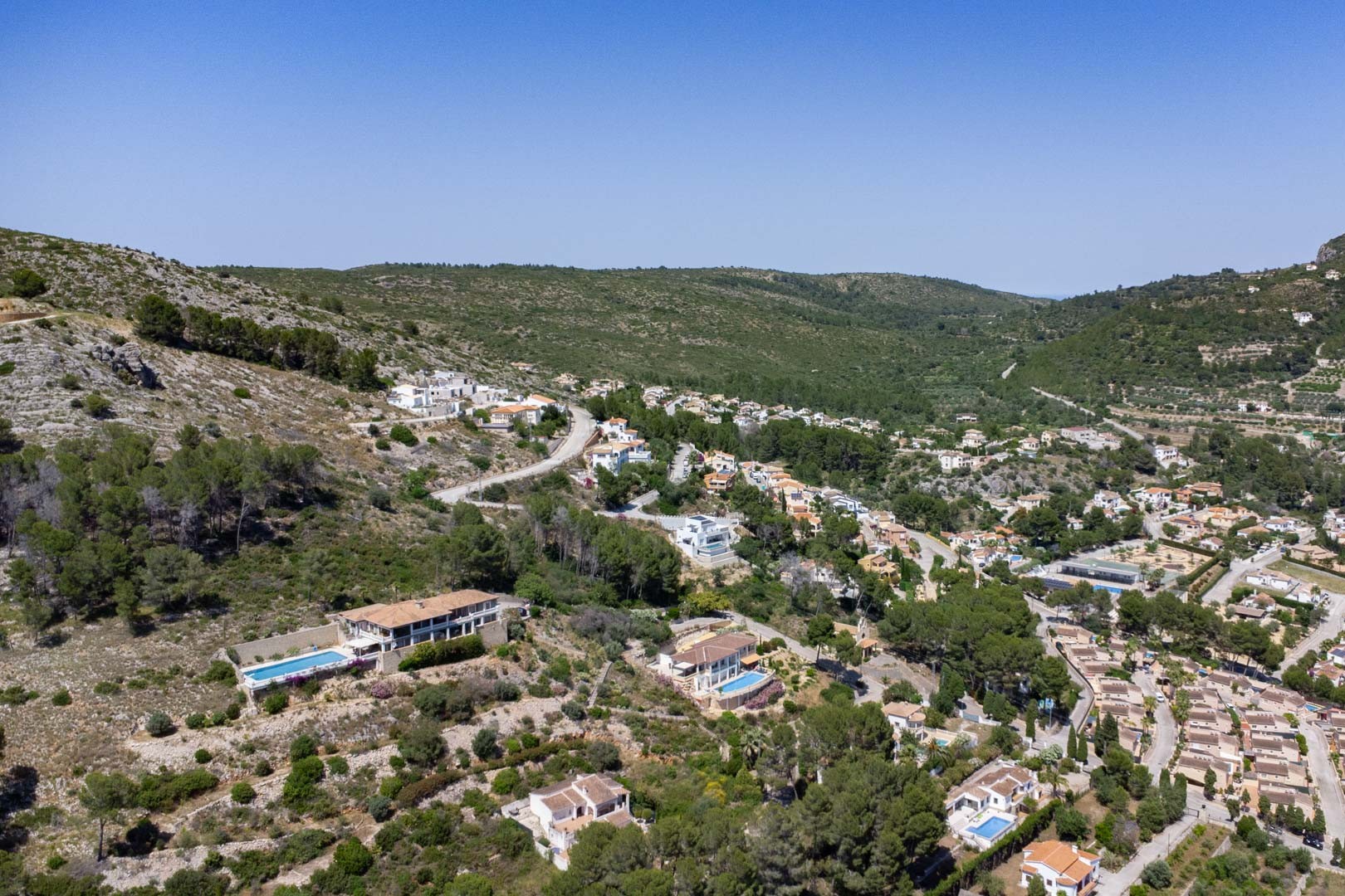 Vista aérea del valle de Jalón en Alcalalí, destacando la topografía elevada de las parcelas y su integración en el entorno natural mediterráneo.