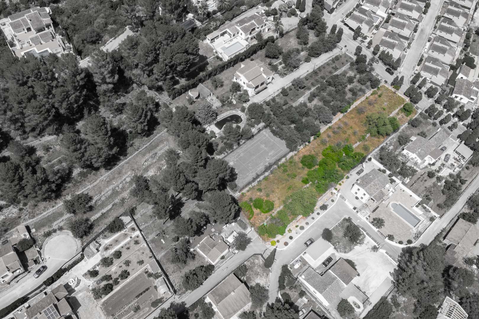 Vista aérea del Residencial VALL DE POP en Alcalalí, destacando en verde las parcelas disponibles integradas en un entorno consolidado con vegetación y servicios cercanos.