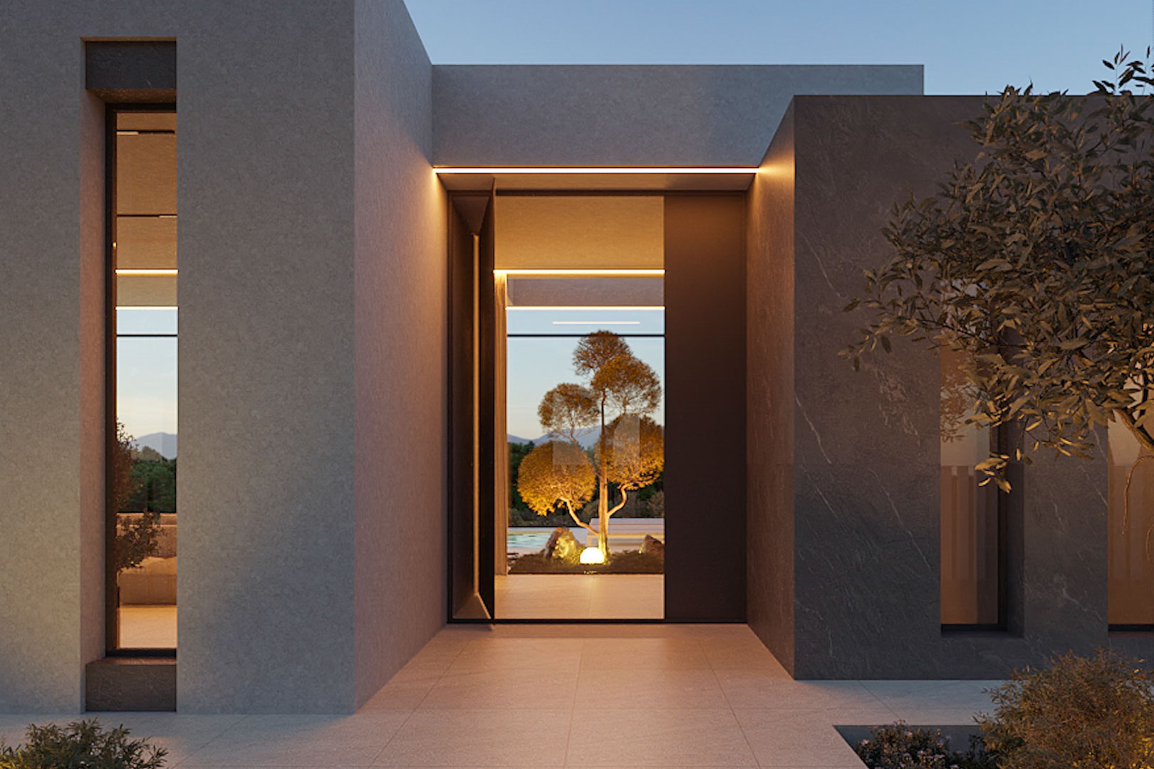 Entrada principal de diseño minimalista con fachada de piedra gris, iluminación LED integrada y vista directa al jardín interior iluminado.