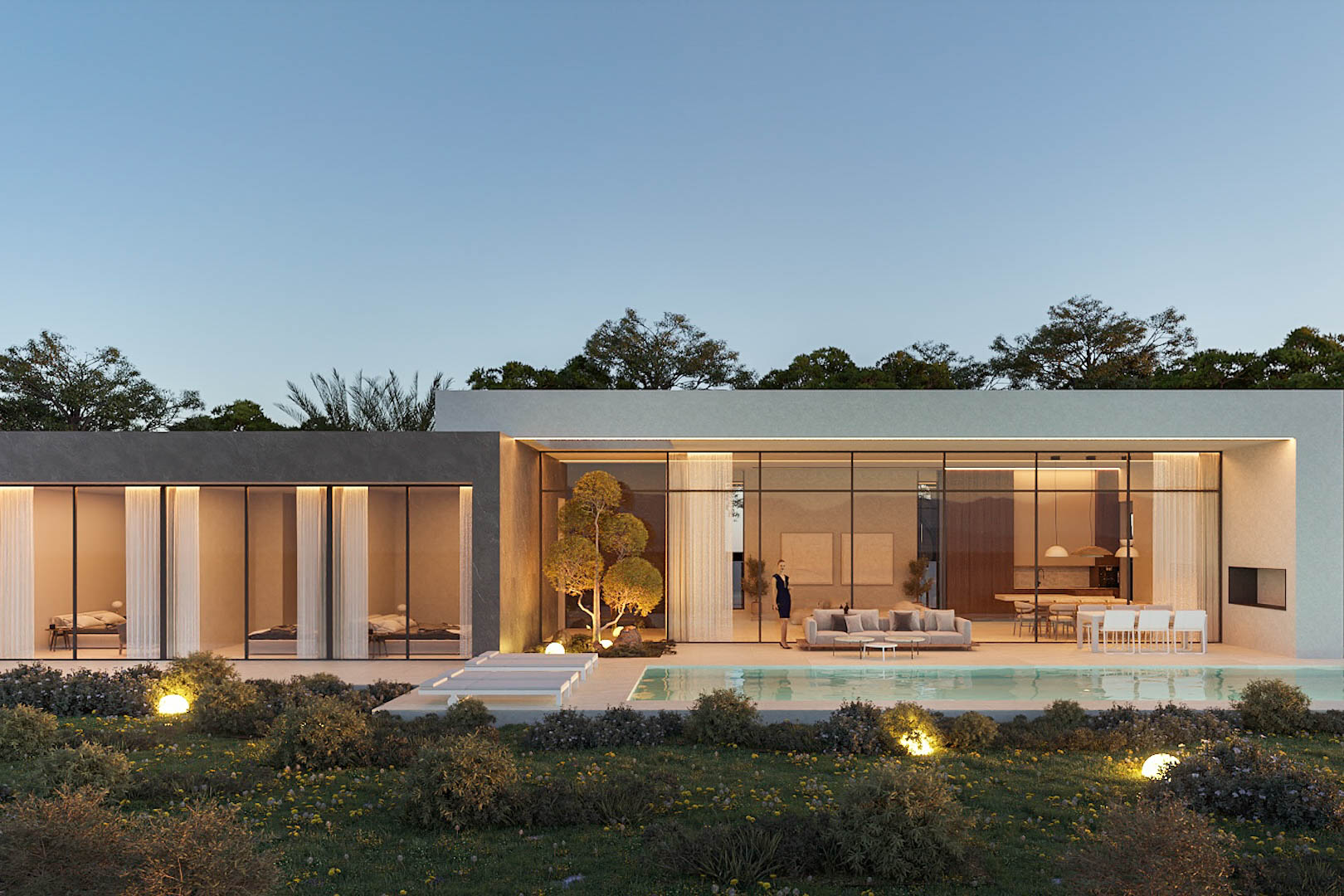 Vista exterior de la villa al atardecer con fachada acristalada, piscina integrada y jardín mediterráneo iluminado con esferas de luz que resaltan la arquitectura de Pepe Giner.