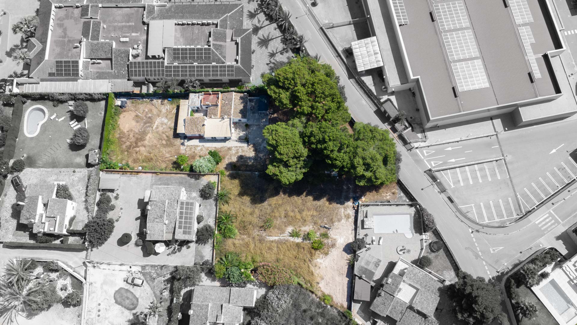 Vista aérea cenital de la parcela de 2.600 m² en Jávea, mostrando la vivienda existente, arbolado consolidado y el potencial de segregación en dos lotes independientes.