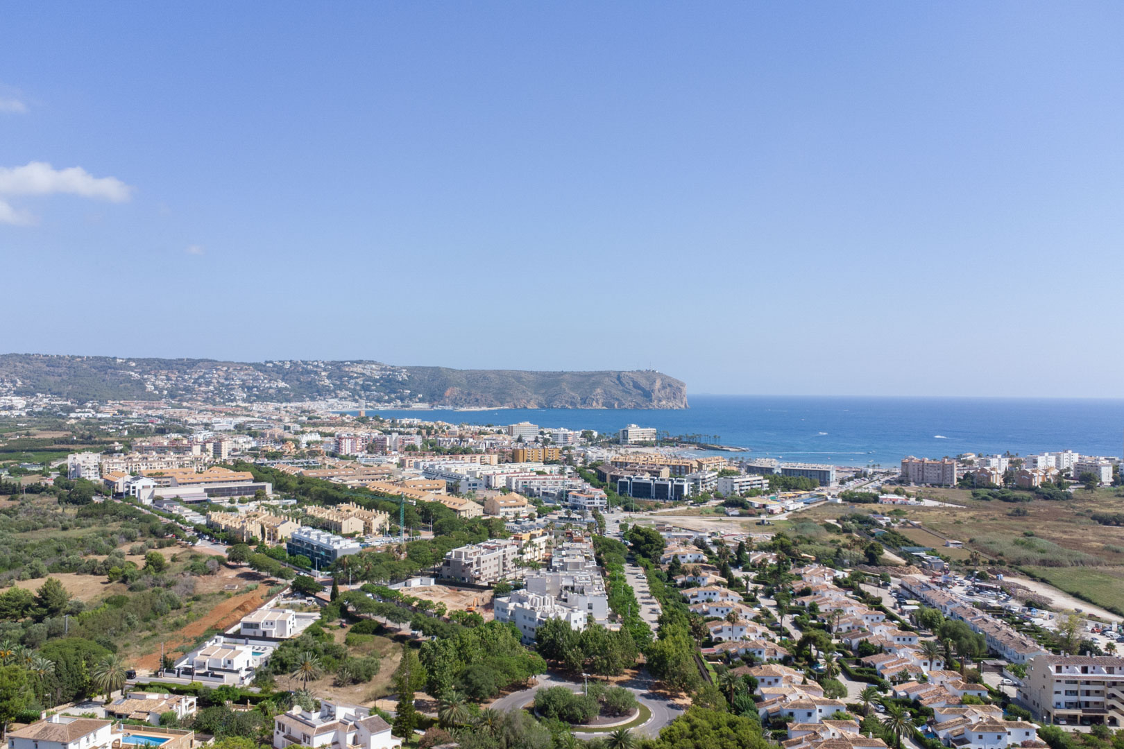 Vista aérea panorámica de Jávea que muestra la proximidad al mar Mediterráneo y el emblemático Cabo de San Antonio bajo un cielo despejado.