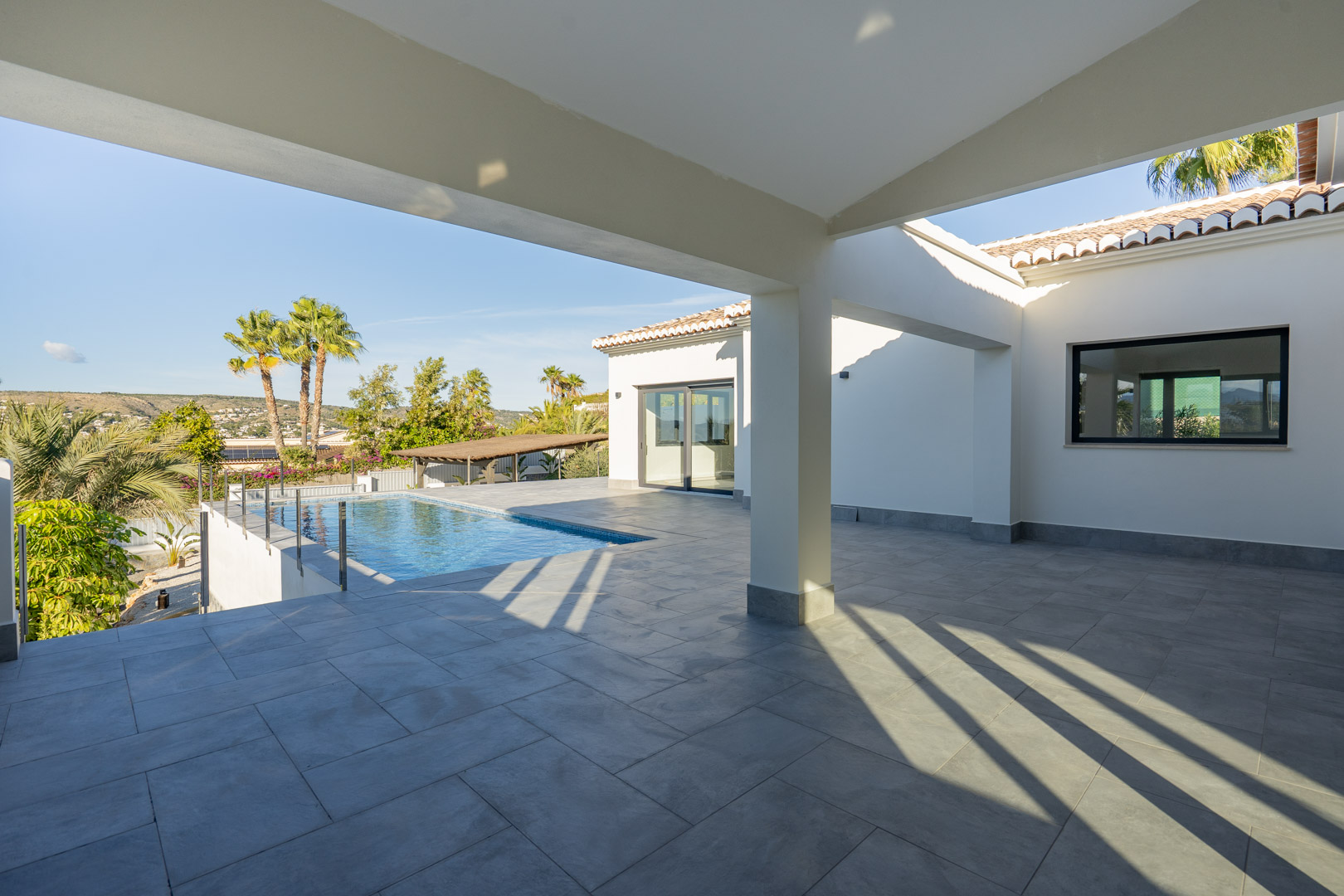 Terraza cubierta con piscina y vistas panorámicas en Jávea.