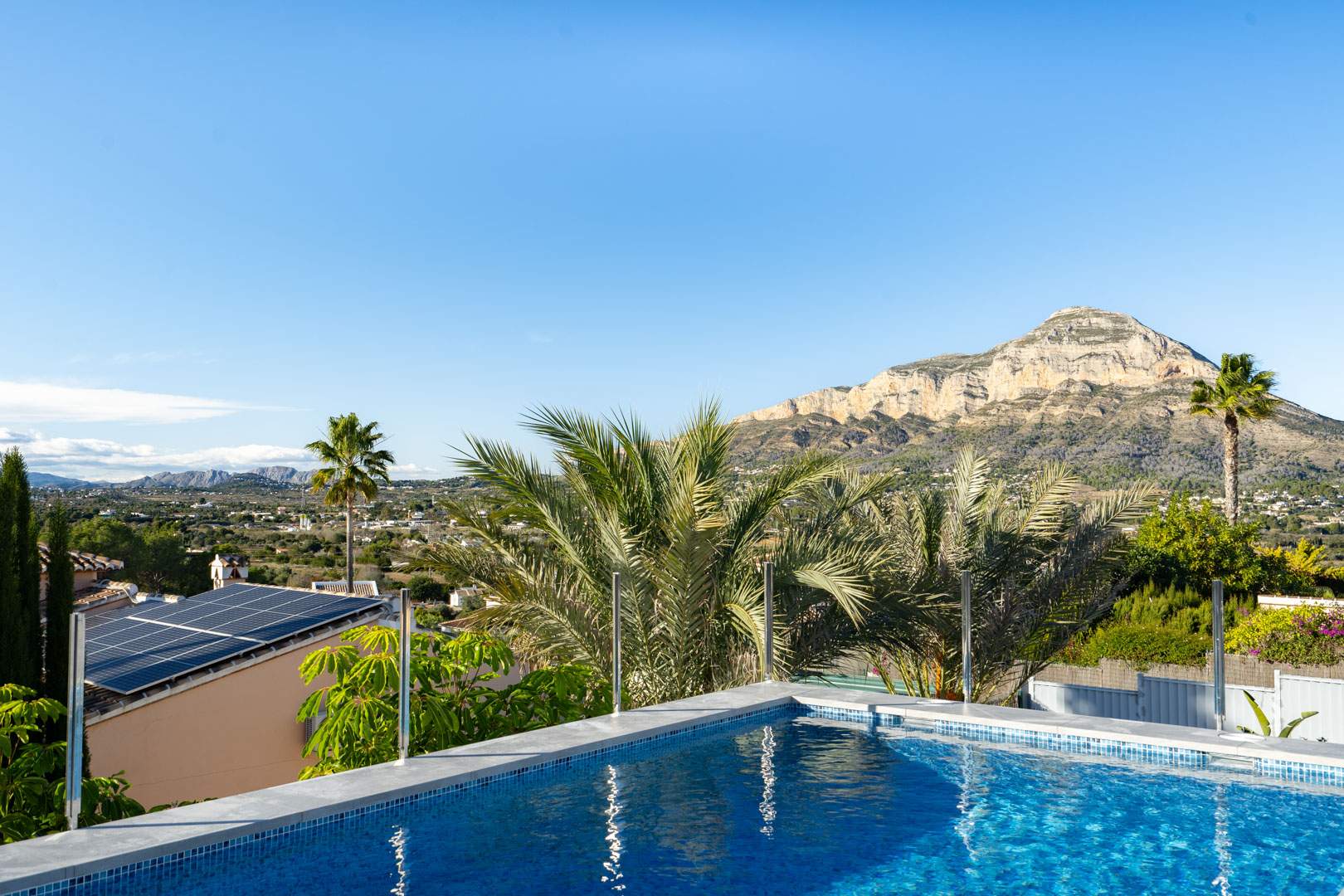 Vista de la piscina con mosaicos azules y el Montgó al fondo, Jávea.