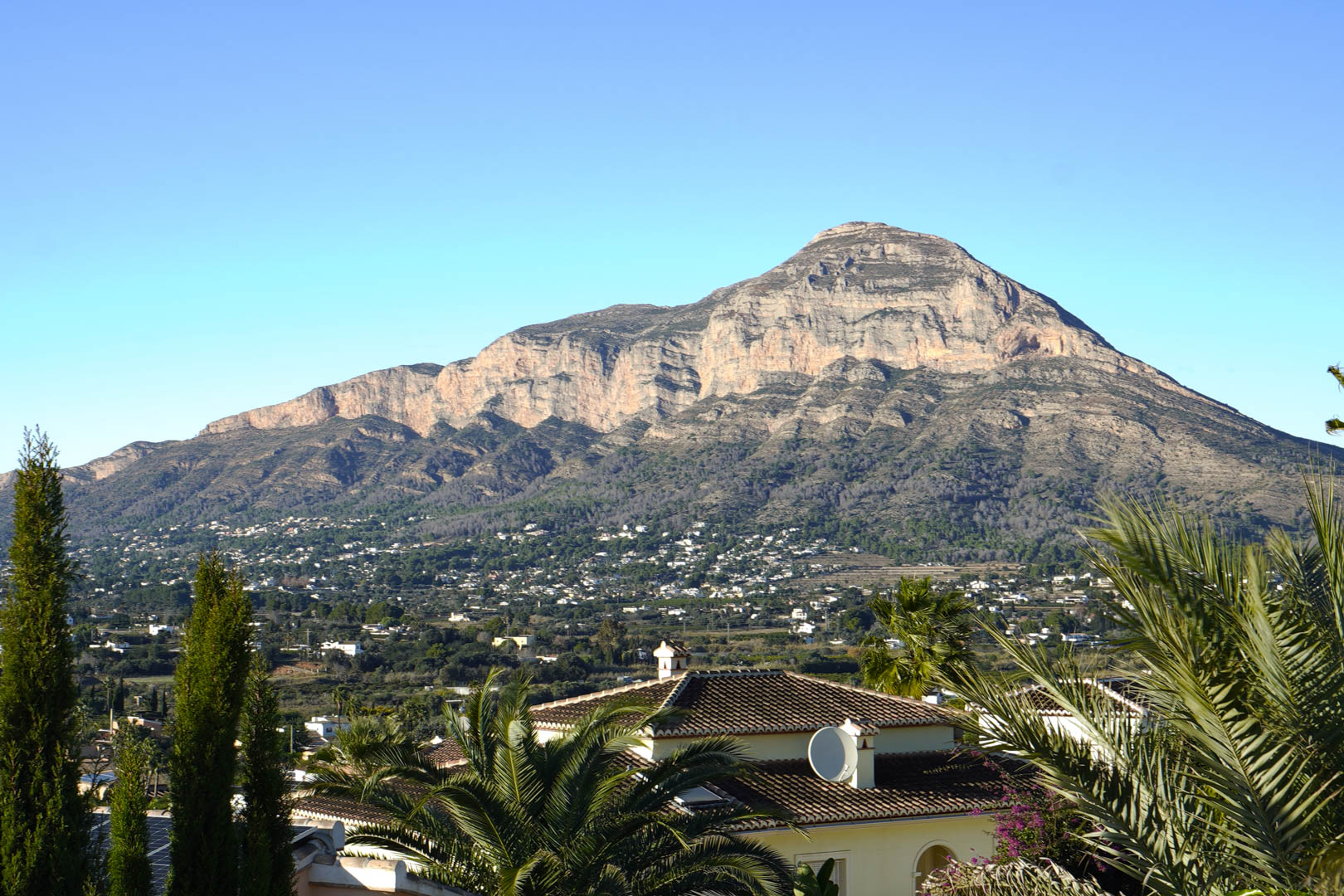 Vista panorámica de la villa con el Montgó al fondo, destacando la integración arquitectónica en el paisaje.