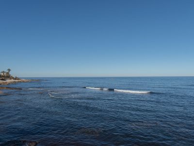 Vista del mar Mediterráneo desde la costa rocosa en Las Rotas, Denia. Un día soleado con cielo despejado.
