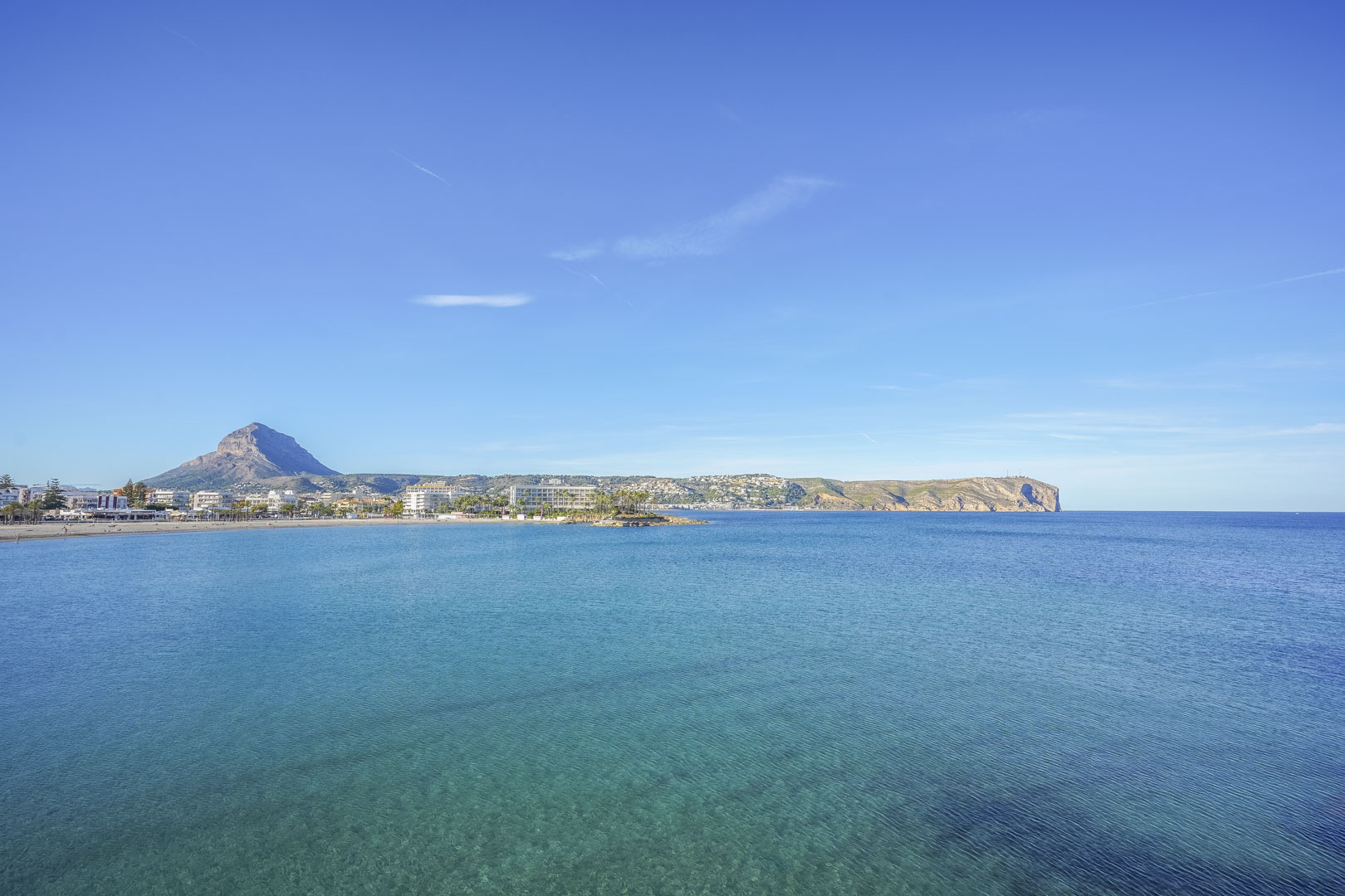 Vista panorámica de la bahía de Jávea con el monte Montgó al fondo y aguas cristalinas, situada a solo un kilómetro de la nueva promoción.