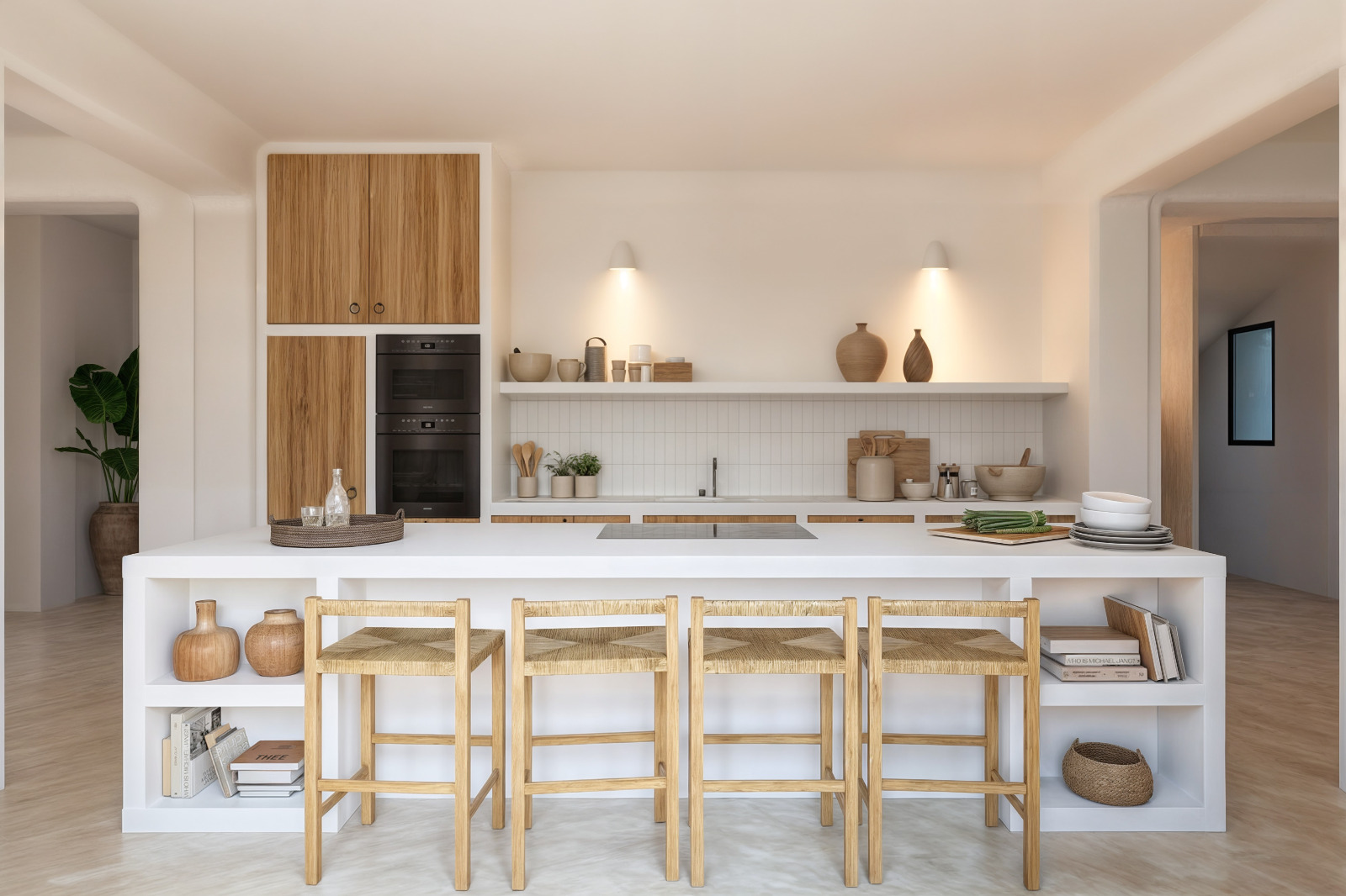 Cocina de estilo ibicenco con isla blanca, taburetes de madera y fibra natural, electrodomésticos integrados y estanterías abiertas con iluminación cálida.