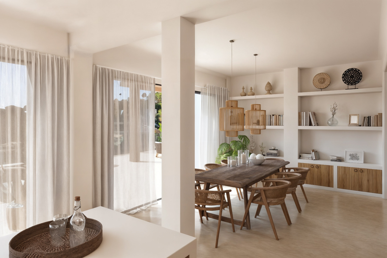 Comedor de estilo ibicenco con mesa de madera maciza, sillas de ratán y estanterías de obra integradas. Grandes ventanales con cortinas ligeras conectan con la terraza exterior.