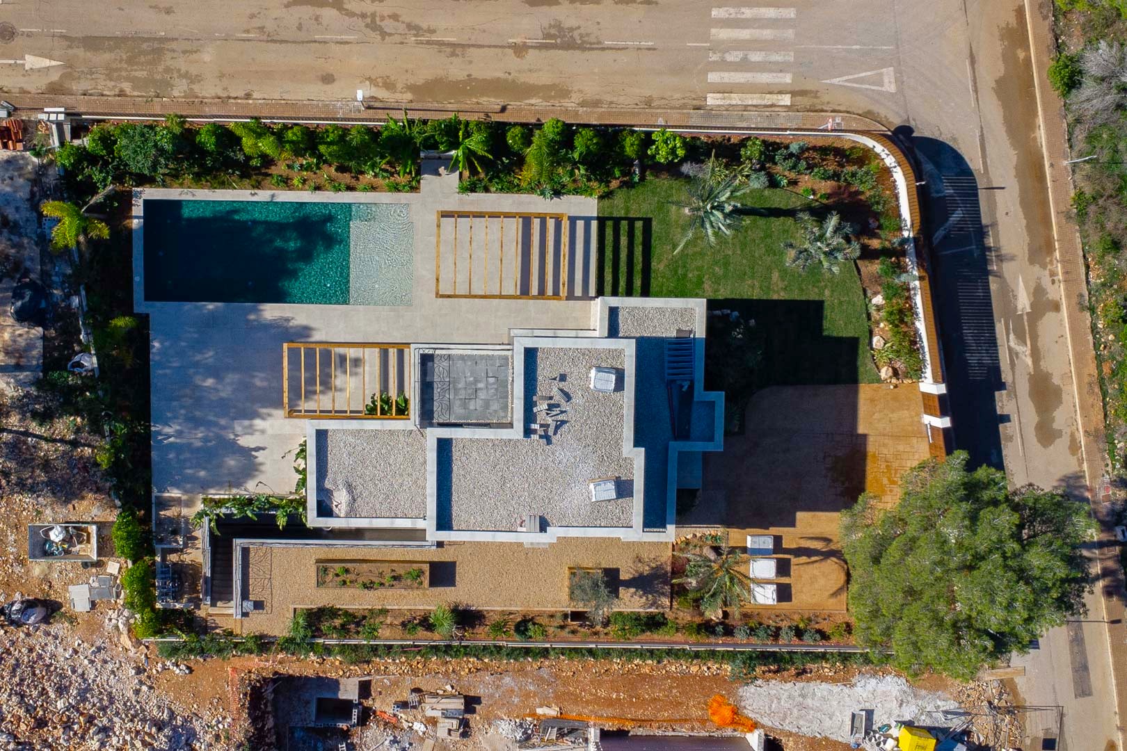 Vista aérea cenital de la villa que muestra la distribución de la parcela, la piscina de estilo Bali, las pérgolas de madera y el diseño paisajístico del jardín mediterráneo.