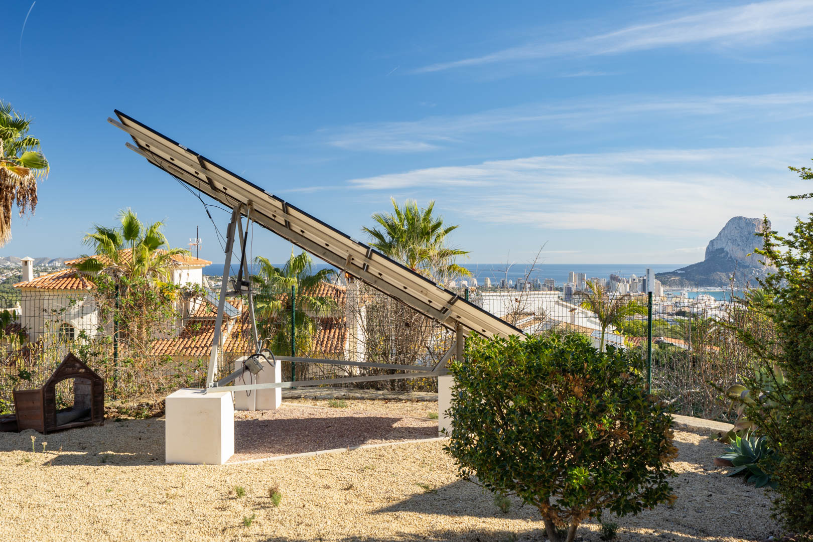 Torre solar motorizada instalada sobre una parcela de grava, con vistas panorámicas al skyline de Calpe y al Peñón de Ifach bajo un cielo despejado.