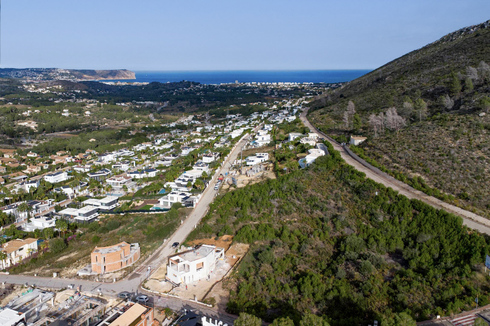 Vista aérea de la parcela en Monte Olímpico, Jávea, mostrando la urbanización consolidada con vistas panorámicas al mar Mediterráneo y al Cabo de San Antonio.