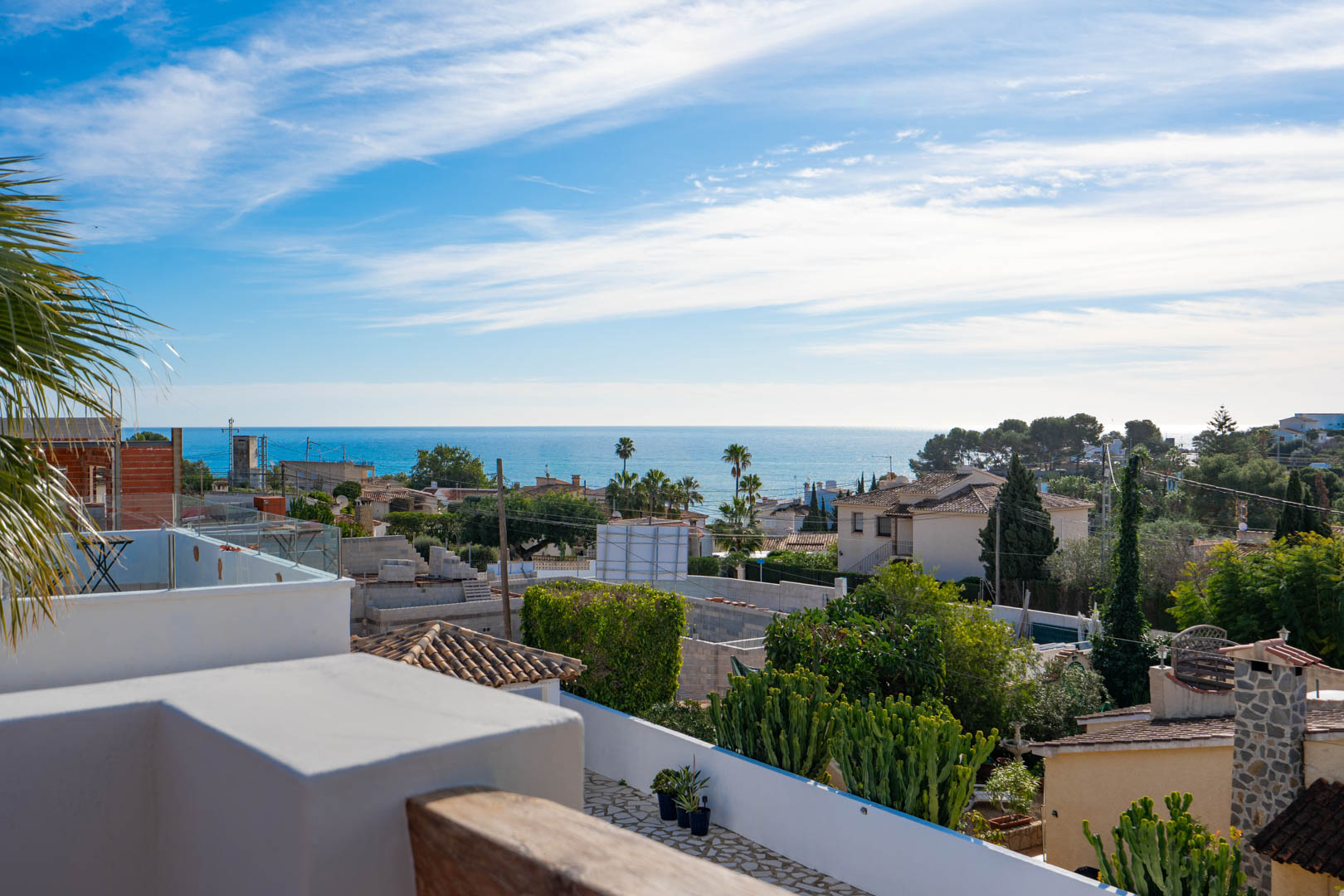 Vistas panorámicas al mar Mediterráneo desde la terraza superior, con barandillas de cristal y detalles en madera integrados en el entorno costero de Benissa.