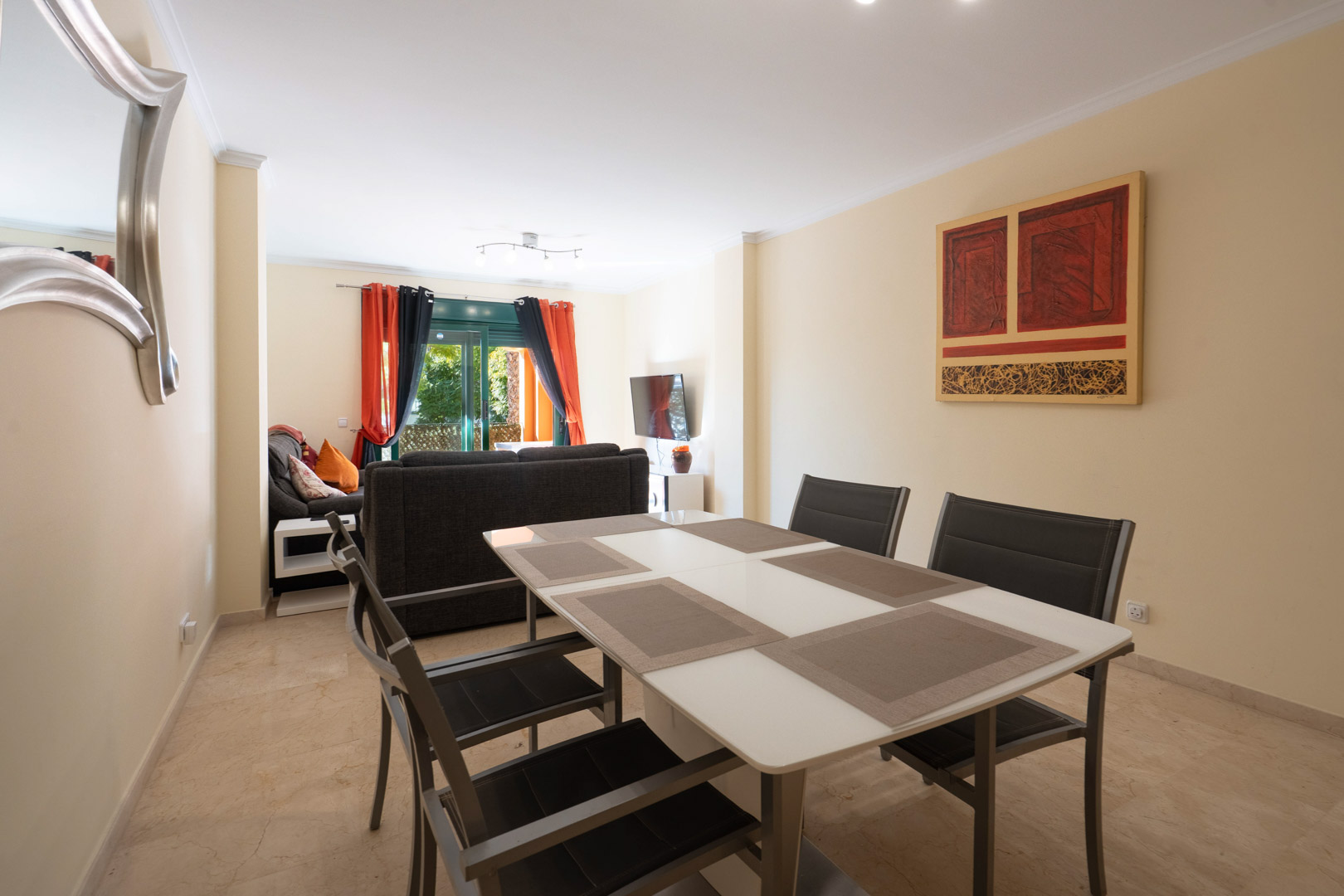 Salón-comedor de planta abierta con suelos de mármol, mobiliario contemporáneo y acceso directo a la terraza a través de amplios ventanales.