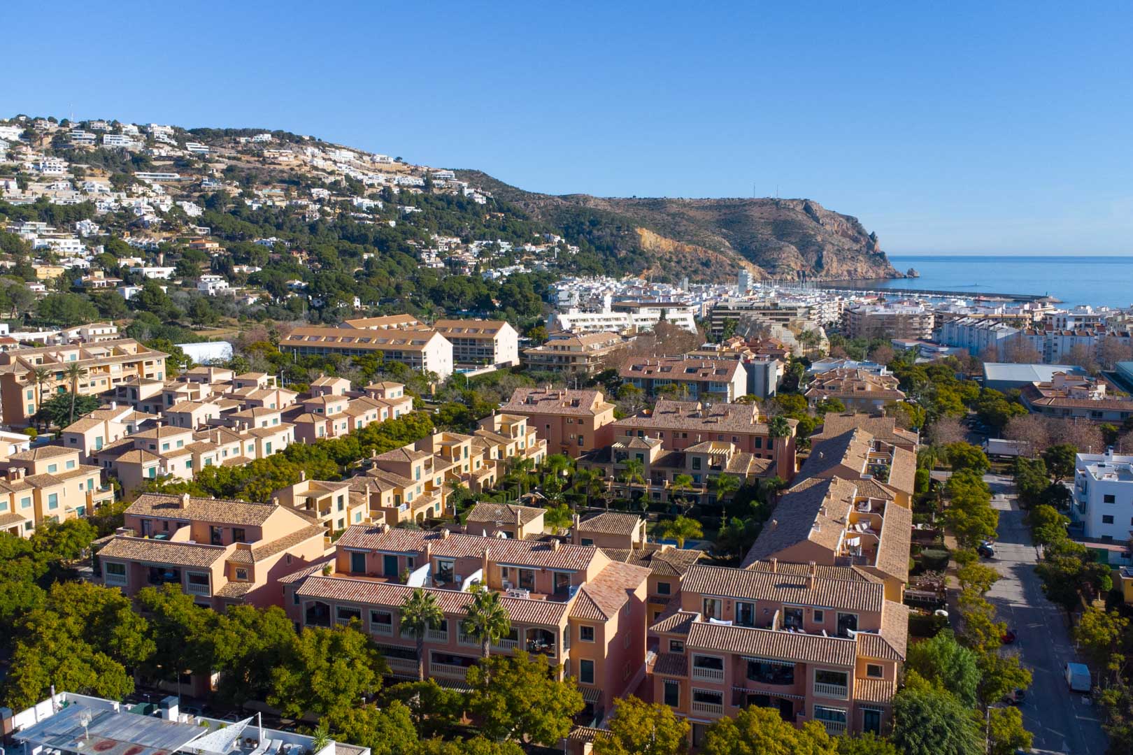 Vista aérea del complejo Floridamar en Jávea, destacando su arquitectura mediterránea, jardines maduros y proximidad al puerto y al mar.