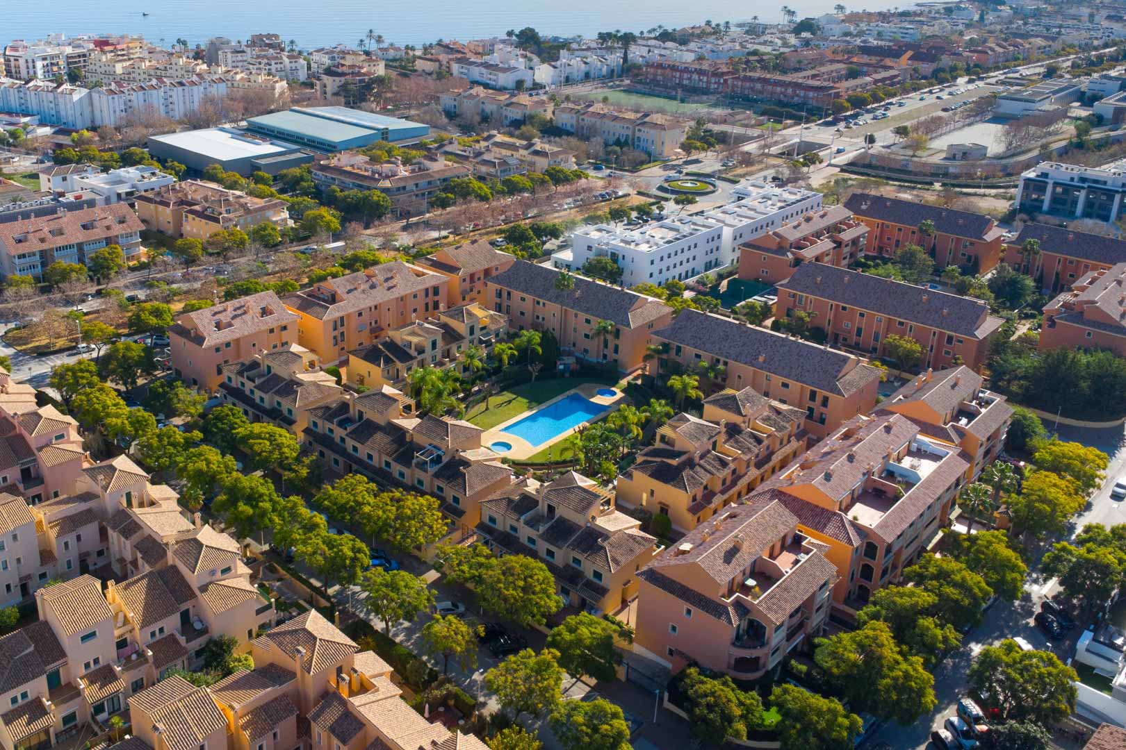 Vista aérea del complejo Floridamar en Jávea, destacando su piscina central rodeada de jardines y la proximidad al mar Mediterráneo.