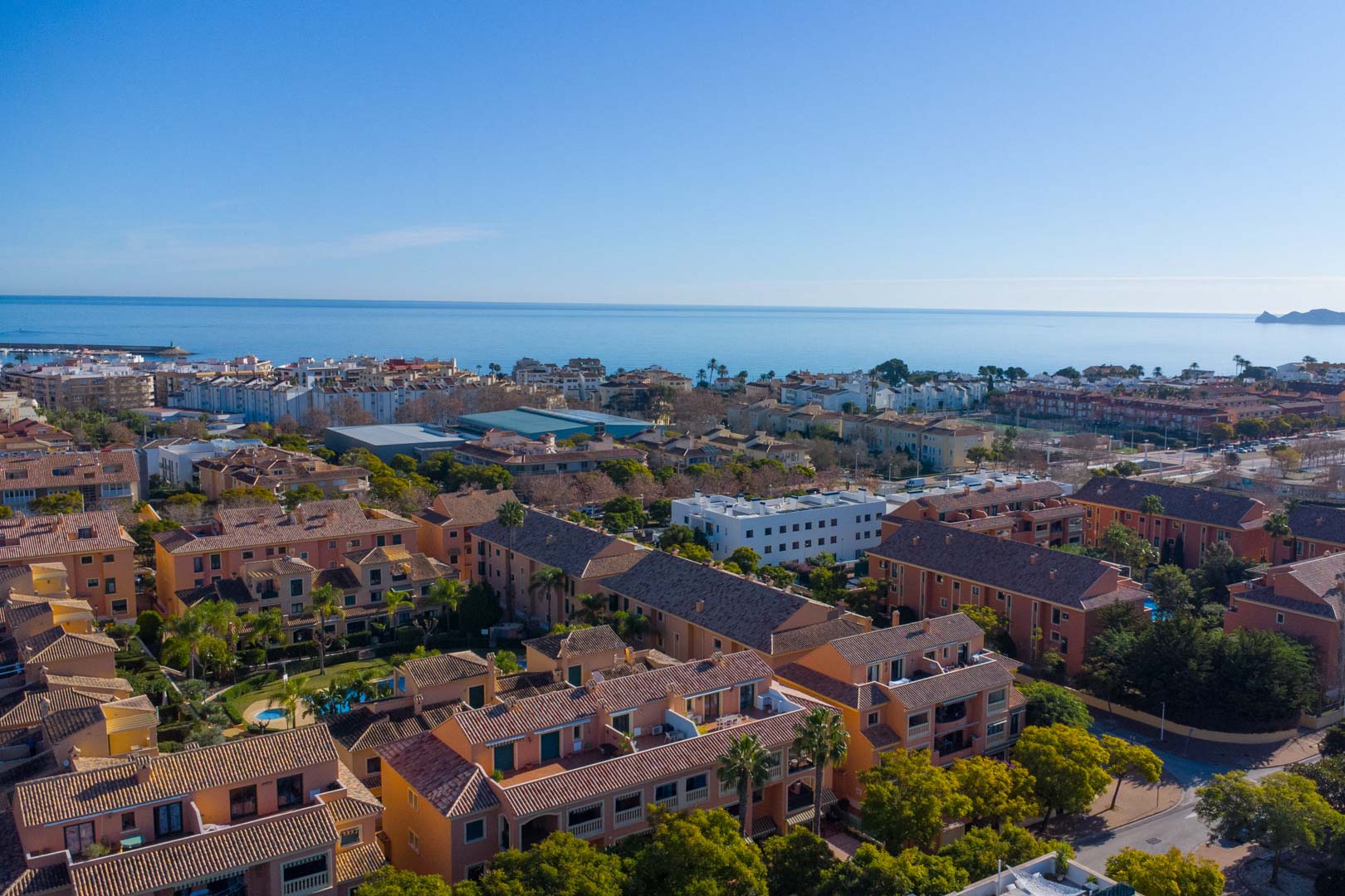 Vista aérea del complejo Floridamar en Jávea, mostrando su arquitectura mediterránea, jardines comunitarios y la proximidad estratégica al mar y al puerto.