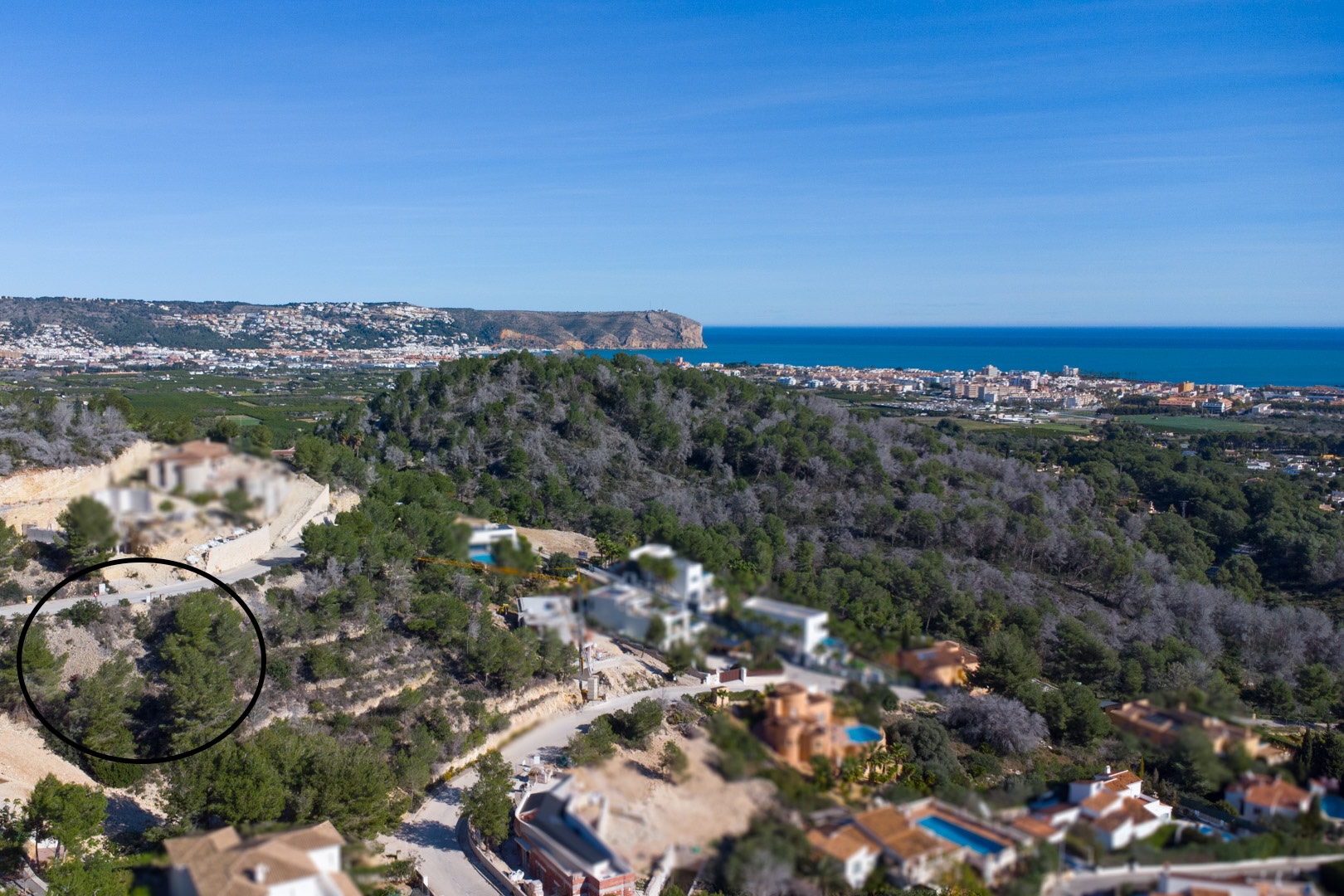 Vista aérea de la parcela elevada en Tosalet 5, rodeada de pinos y con vistas panorámicas al mar Mediterráneo y al litoral de Jávea.
