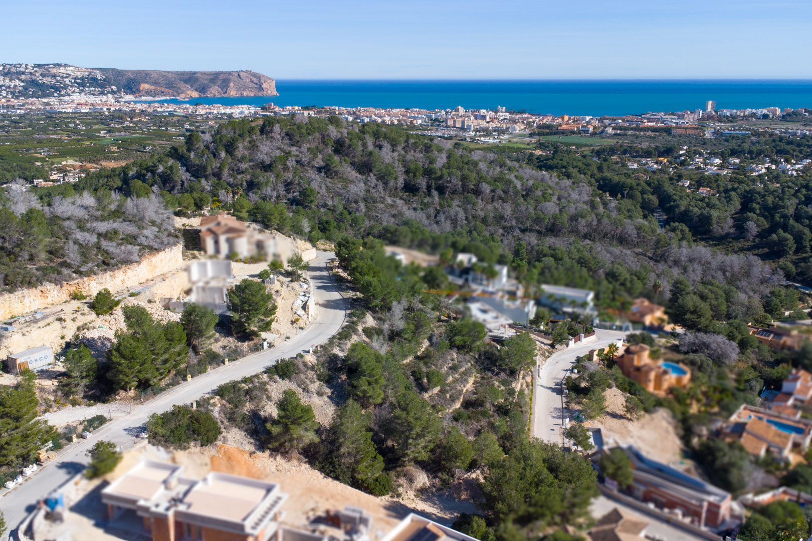 Vista aérea de la urbanización Tosalet 5 en Jávea, destacando las parcelas elevadas rodeadas de pinos con vistas al mar Mediterráneo y al Cabo de San Antonio.