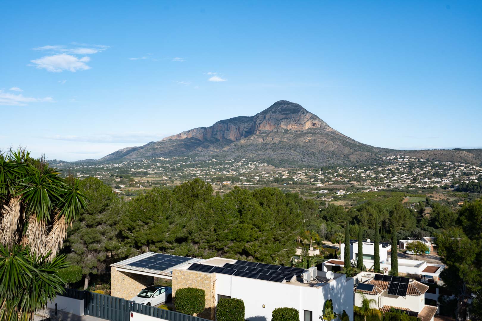 Vista panorámica del macizo del Montgó desde la propiedad, destacando la instalación de paneles solares en la cubierta y el entorno residencial rodeado de pinos.