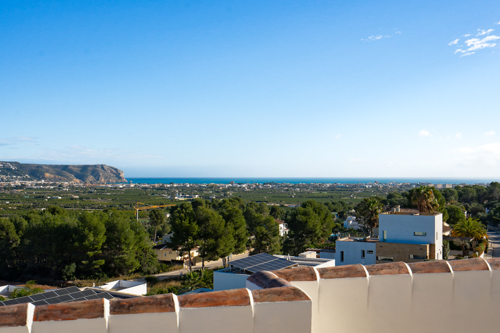 Vistas panorámicas desde la terraza superior hacia el mar Mediterráneo y la costa, mostrando la silueta del cabo y la vegetación local bajo un cielo despejado.