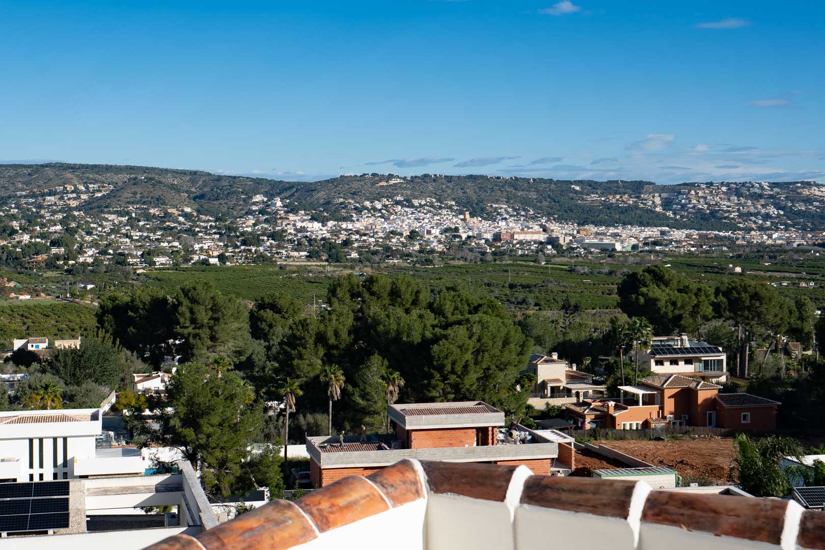 Vistas panorámicas desde la terraza superior hacia el valle y las colinas circundantes, destacando la vegetación mediterránea y el entorno residencial de la zona.