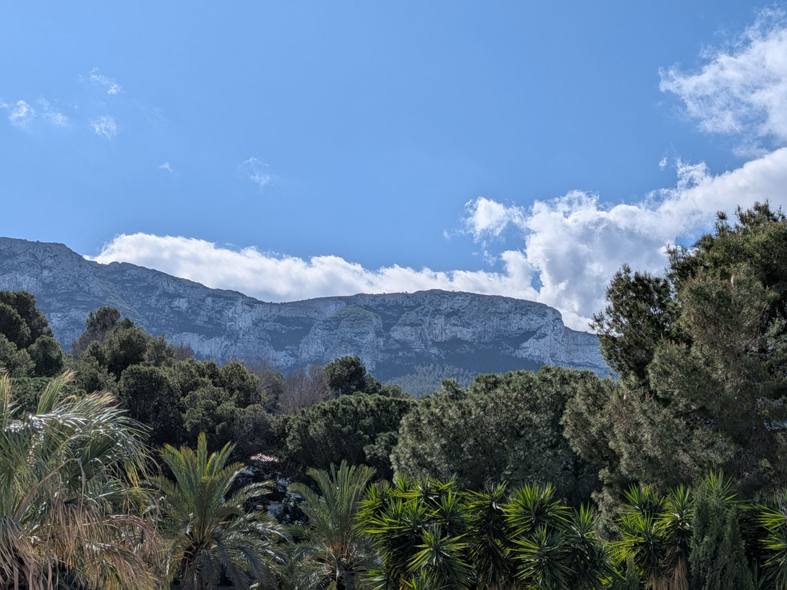 Vistas despejadas al Parque Natural del Montgó desde la propiedad, rodeada de vegetación mediterránea con pinos y palmeras.