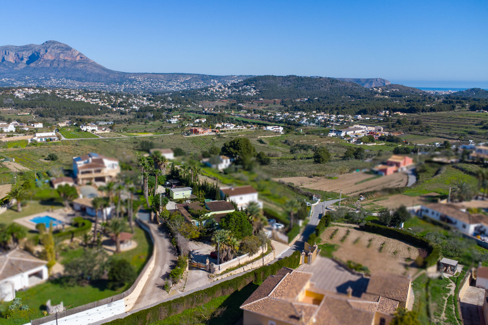 Vista aérea de la finca tradicional y su parcela rústica, destacando las vistas panorámicas hacia el Montgó y el mar Mediterráneo en Benitachell.