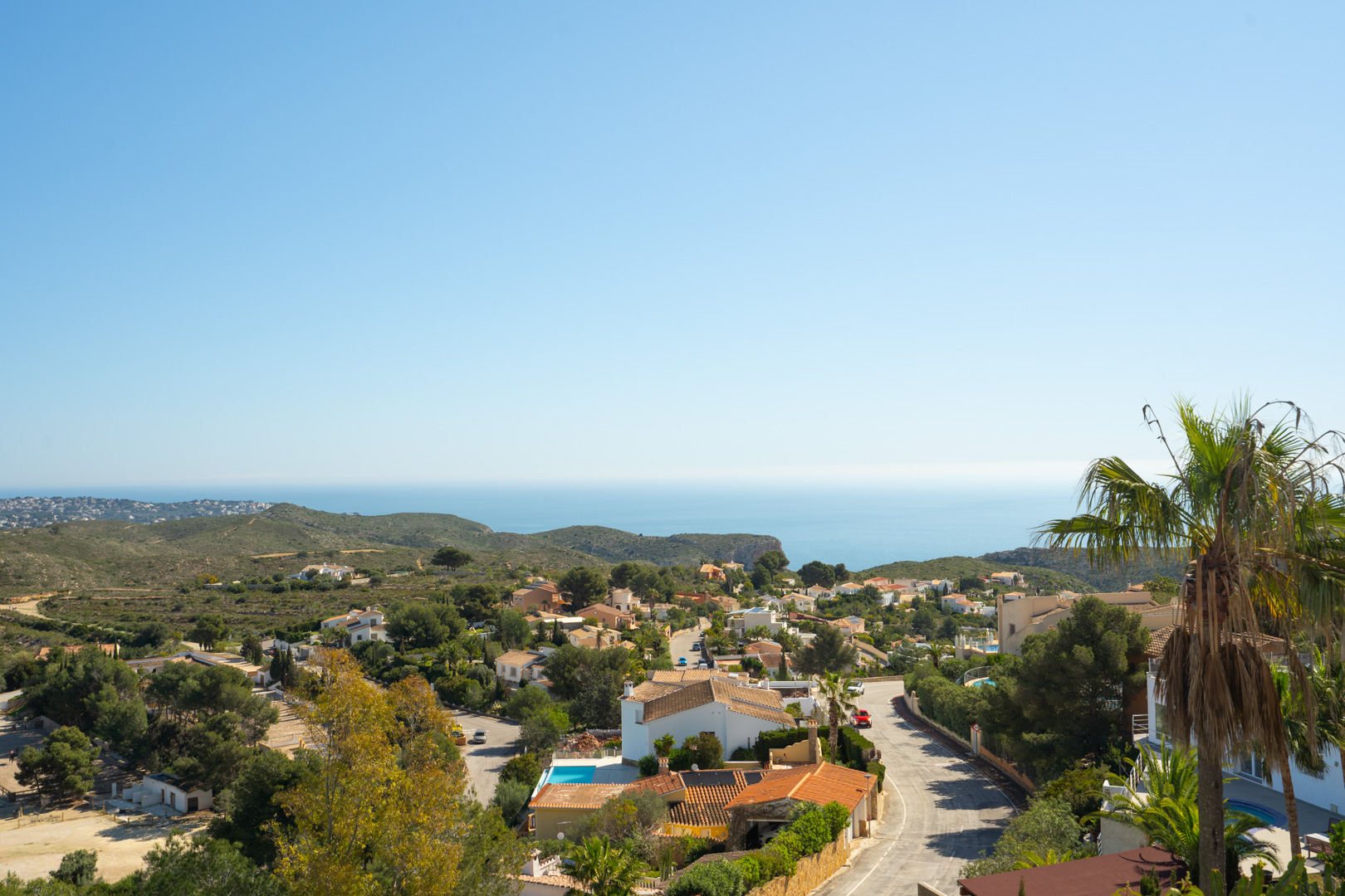 Vistas panorámicas desde la propiedad hacia la urbanización Cumbre del Sol, el mar Mediterráneo y las colinas circundantes bajo un cielo despejado.