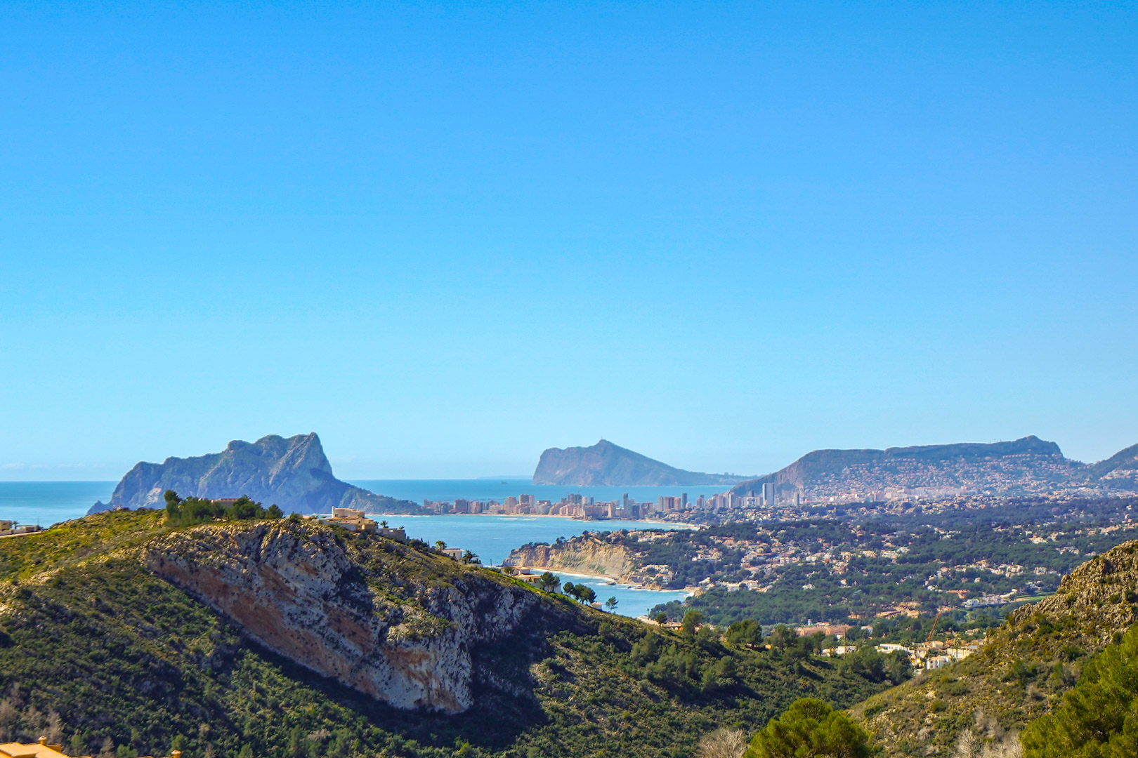 Vistas panorámicas desde la propiedad que abarcan el Peñón de Ifach en Calpe, la costa de Benissa y el perfil urbano de Benidorm bajo un cielo despejado.