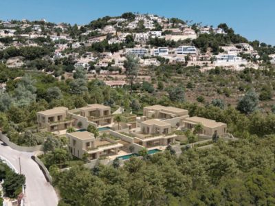 Vista aérea de un complejo residencial moderno con villas de fachadas claras y piscinas privadas, integrado en una ladera verde y arbolada.