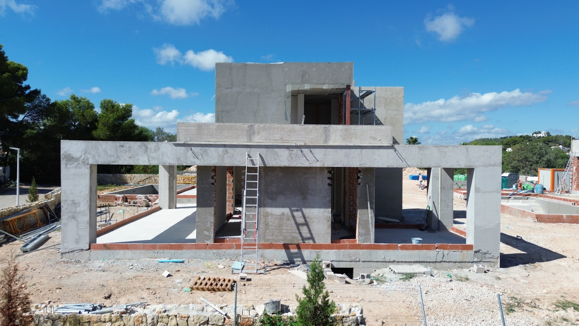 Estructura de hormigón de la villa en fase inicial de construcción, mostrando el esqueleto y aberturas para ventanales. Estructura de hormigón de la villa en fase inicial de construcción, mostrando el esqueleto y aberturas para ventanales.