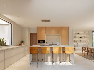 Cocina abierta moderna con isla central, encimera clara y cuatro taburetes tapizados en naranja. Destacan los muebles de madera, el horno integrado y la iluminación empotrada.