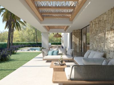 Terraza cubierta con mobiliario de exterior moderno, pared de piedra natural y techo de madera con celosía. Vistas a un jardín con césped, plantas florales y palmeras, con piscina al fondo.