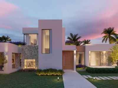 Fachada moderna de villa al atardecer con paredes blancas, revestimiento de piedra natural, puerta de madera e iluminación exterior destacando una fuente.