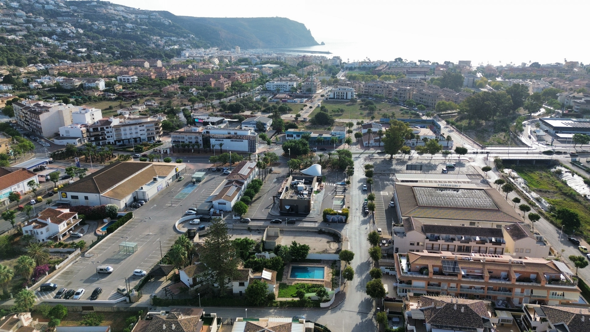 Vista aérea de la propiedad cerca de servicios, con piscina privada y amplio estacionamiento.