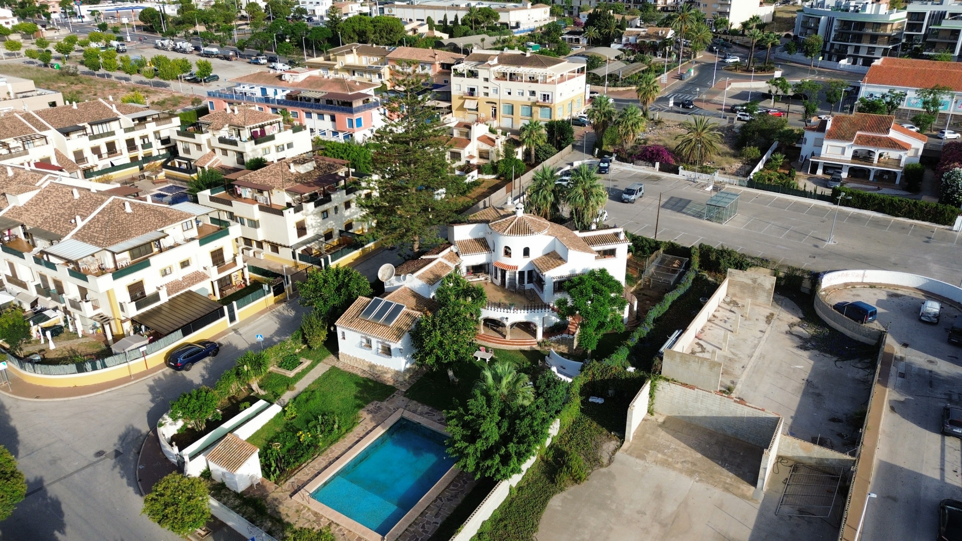 Vista aérea de la villa con piscina azul, rodeada de jardines y vegetación en Jávea.
