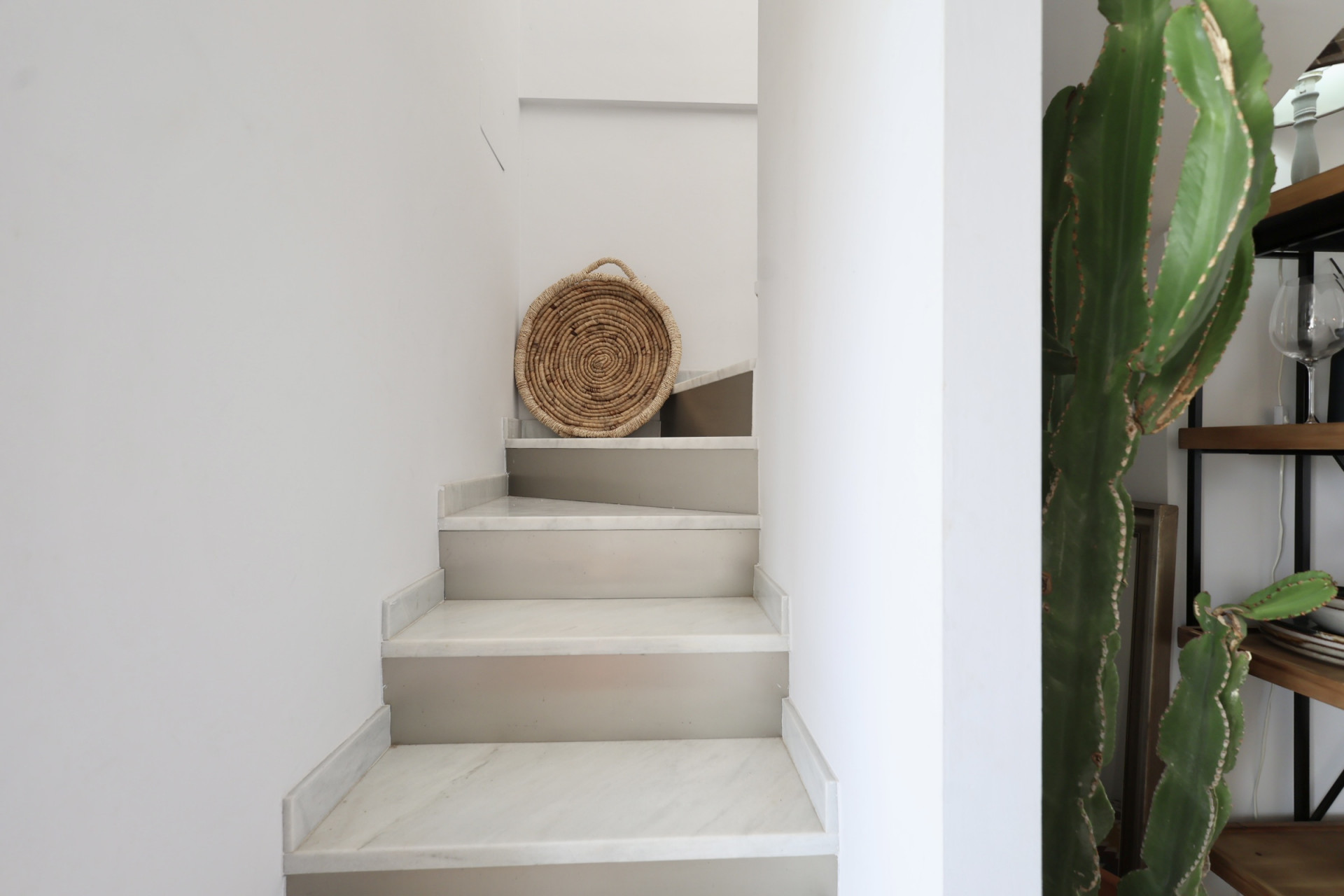 Detalle de escalera con peldaños de mármol y decoración rústica en Jávea.