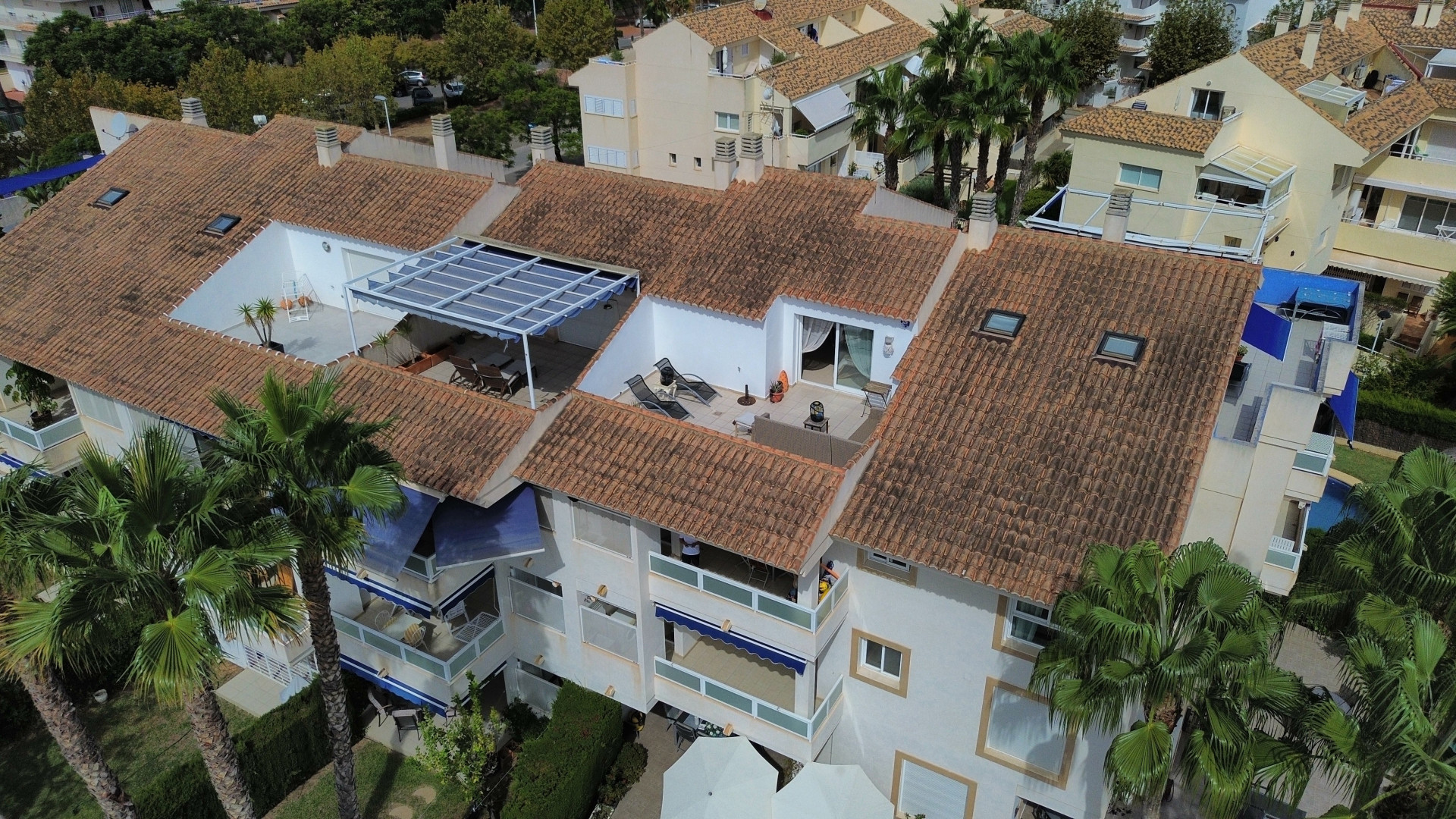 Vista aérea del ático dúplex con terraza solárium, toldo y tejas de terracota en Jávea.