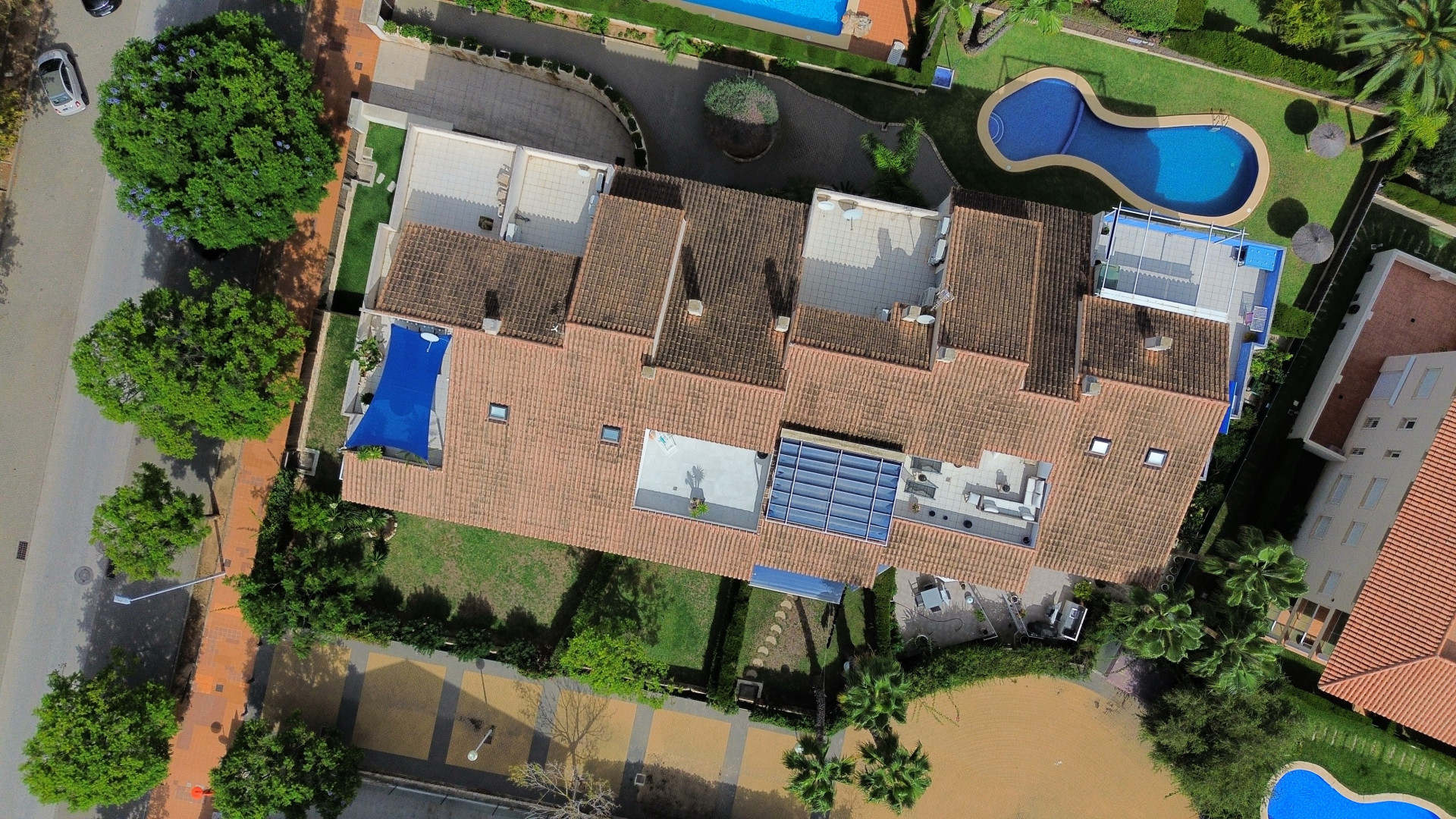 Vista aérea del ático dúplex con terrazas, piscina y jardines exuberantes.