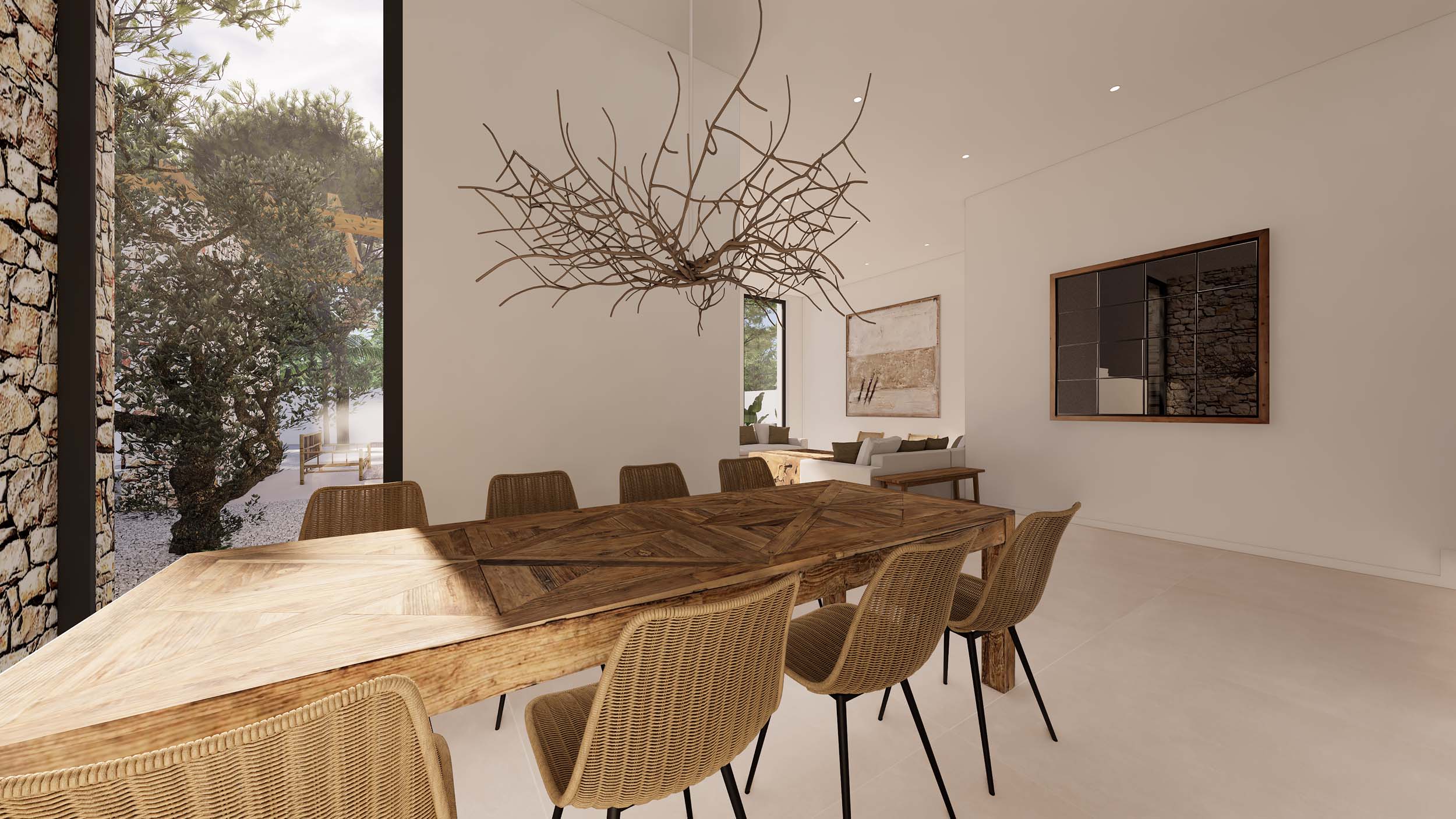 Comedor de estilo ibicenco con mesa de madera rústica y sillas de mimbre. Destaca la lámpara escultórica de ramas y el gran ventanal con vistas al jardín y muro de piedra natural.