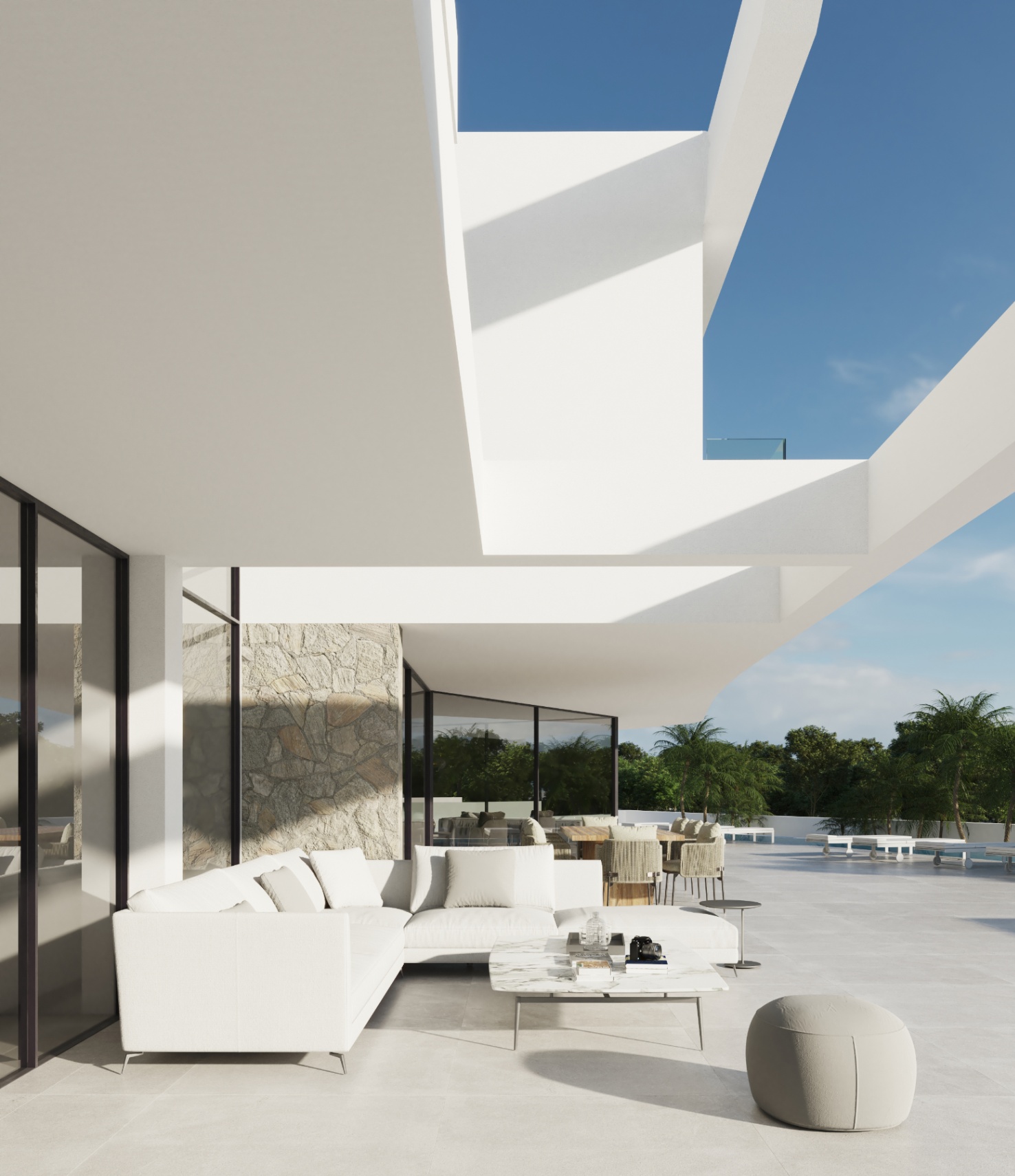 Terraza principal con zona de estar exterior, sofás de diseño y acabados en piedra natural bajo una estructura arquitectónica de líneas blancas vanguardistas.